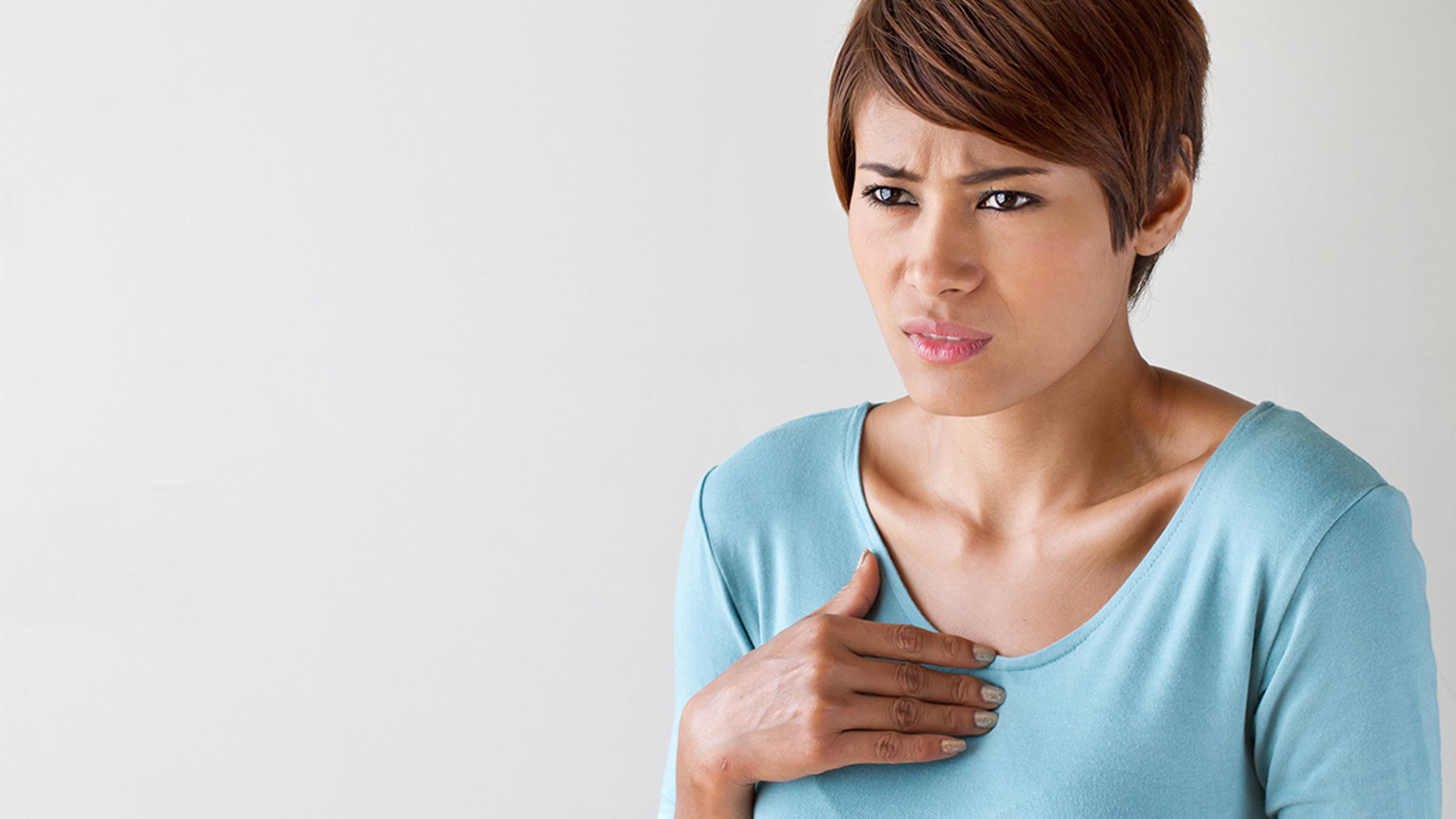 Woman holding chest irregular heartbeat