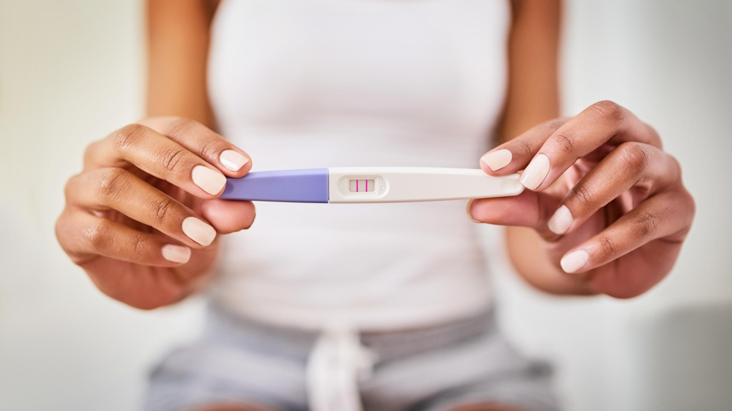 Woman holding positive pregnancy test