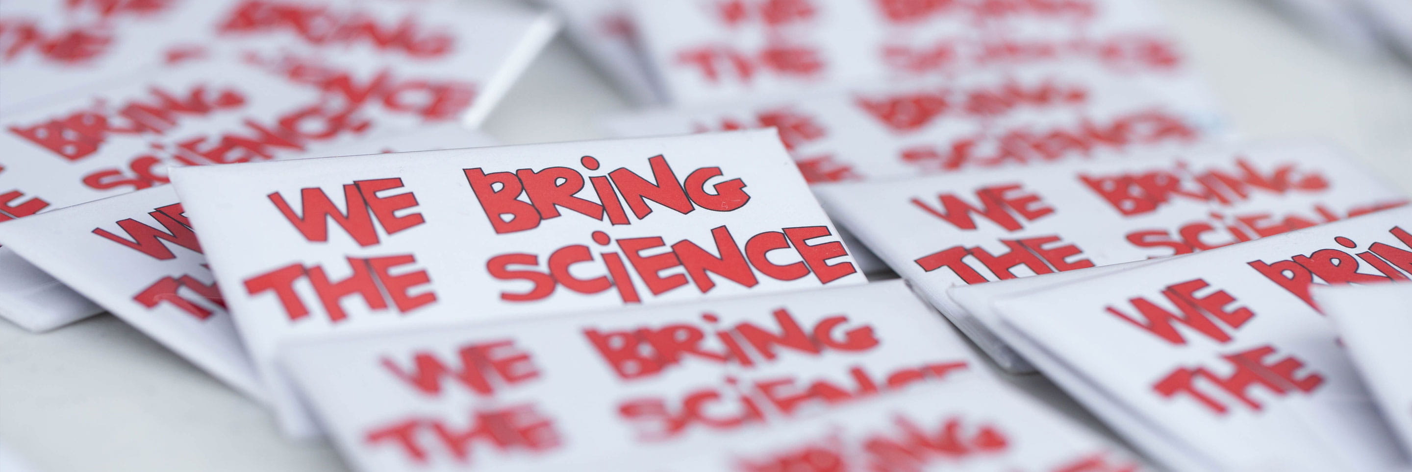 Pile of stickers that say 'We bring the science'