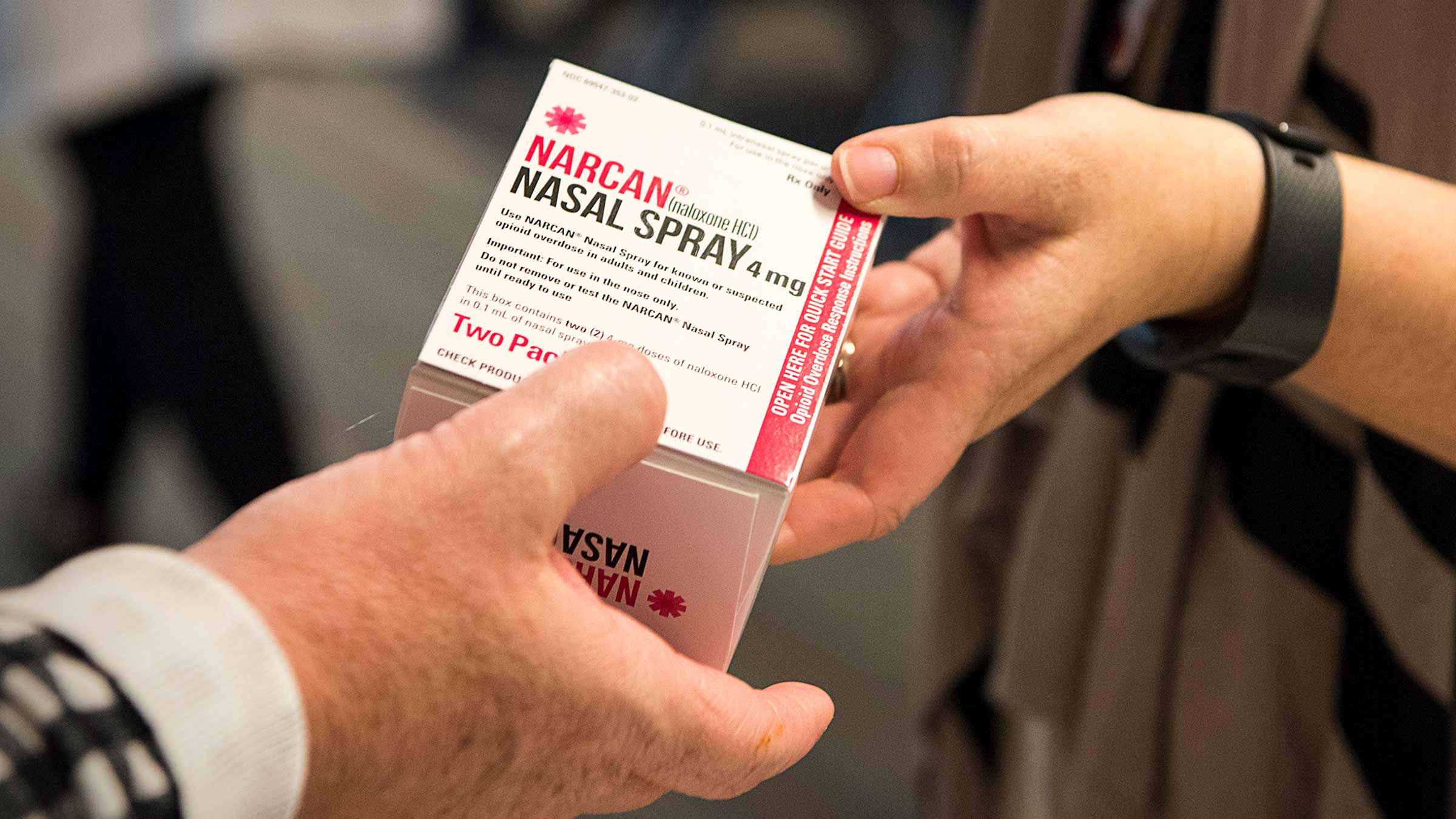 Person handing out a package containing Narcan