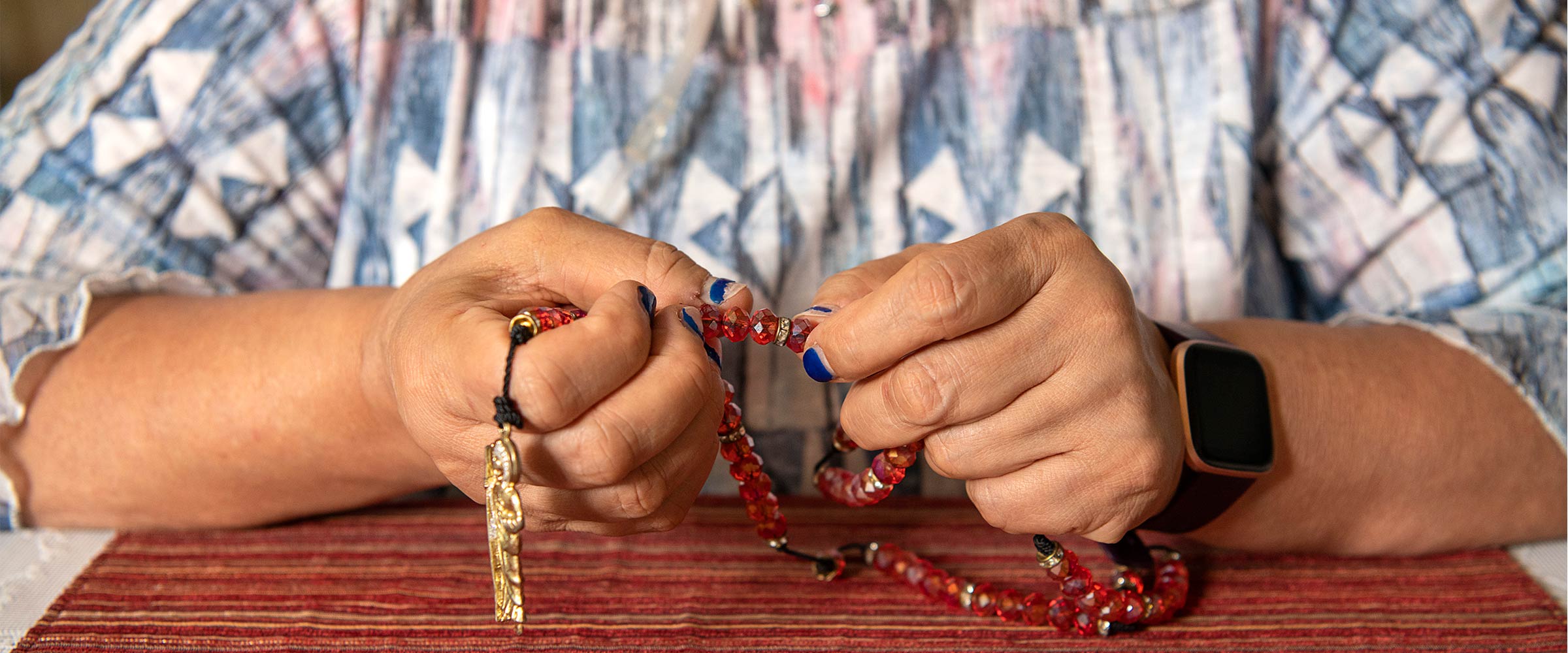 Raven's mothers hands holding prayer beads