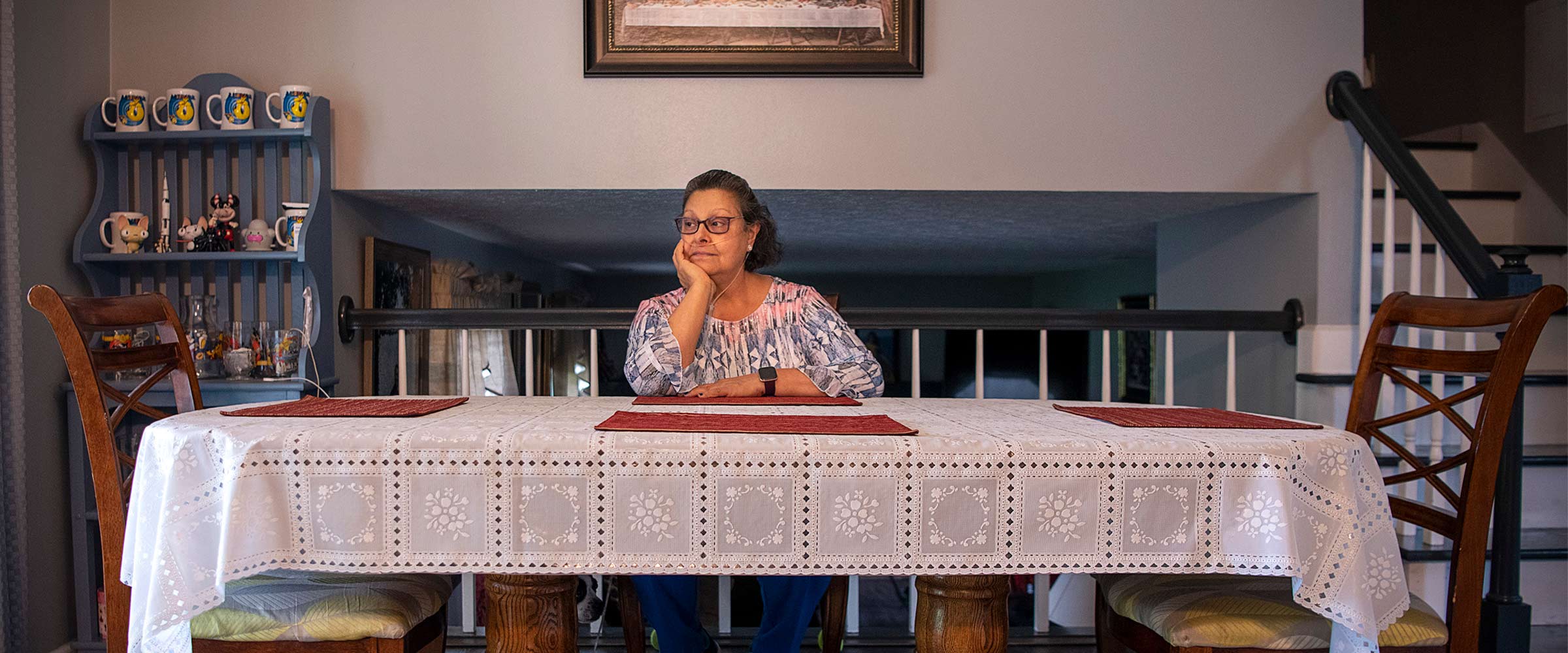 Raven's mother sitting at her kitchen table with an oxygen tank