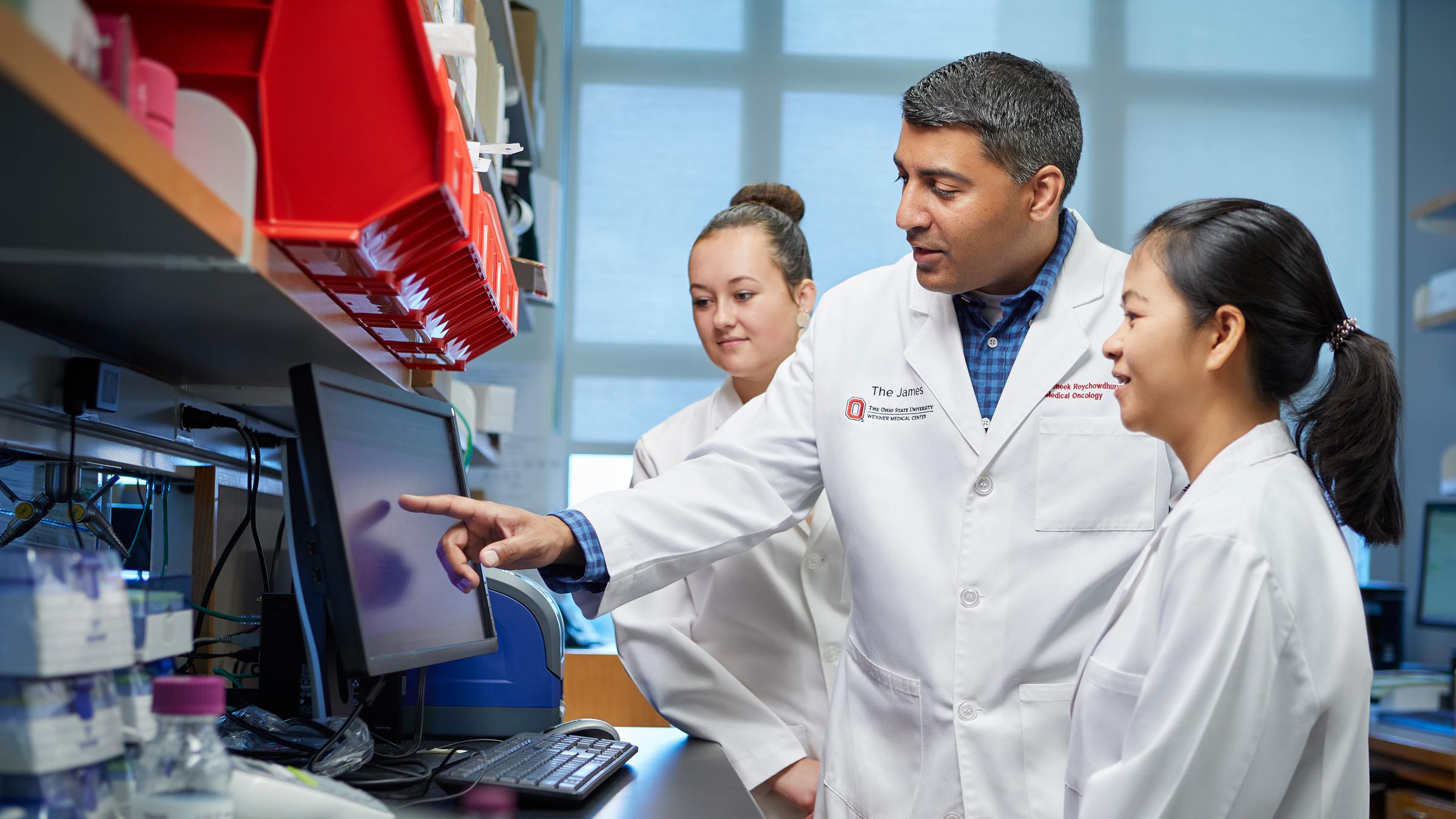Sameek Roychowdhury, MD, PhD, consults with research colleagues in a precision cancer medicine lab at the OSUCCC – James.