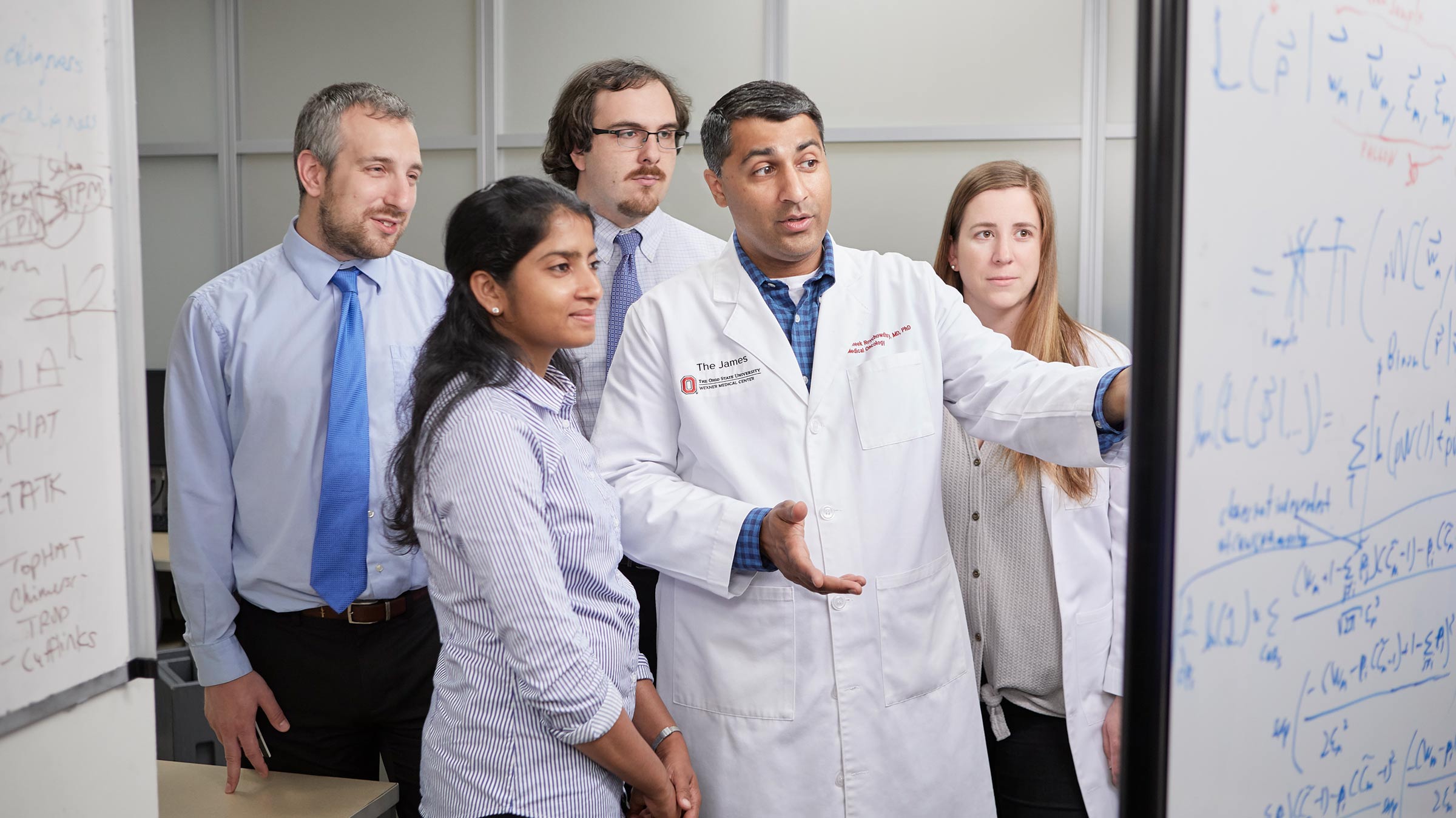 Sameek Roychowdhury, MD, PhD, consults with members of his laboratory.