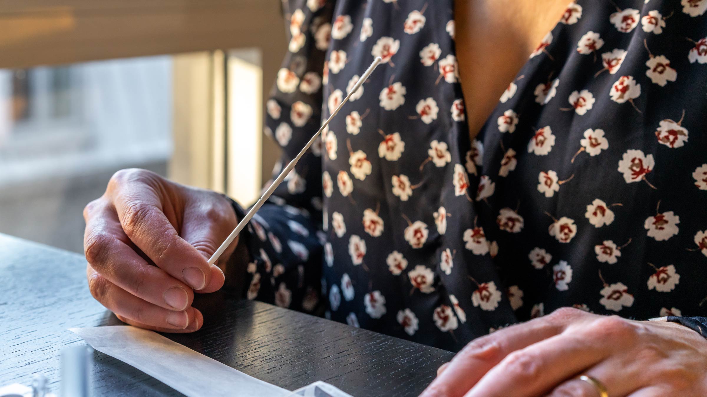 Woman holding a COVID-19 home test kit