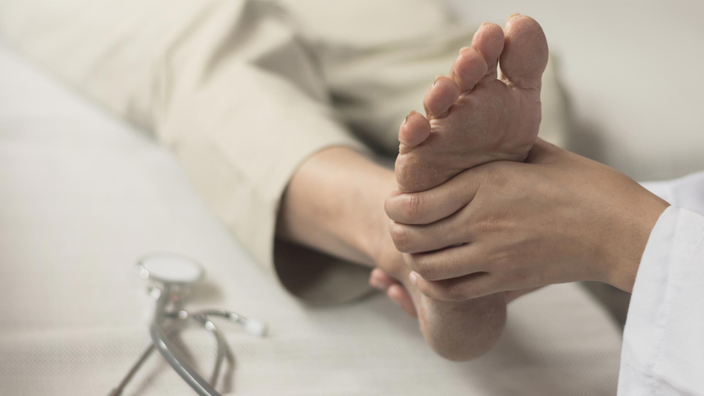 Doctor with hand on patient foot performing exam