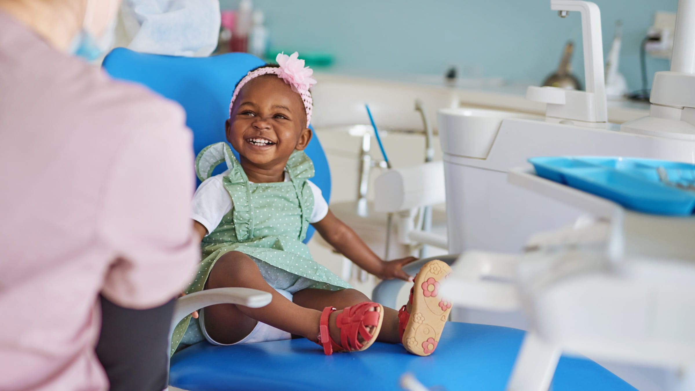 Toddler girl sitting in a chair at her dentist appointment