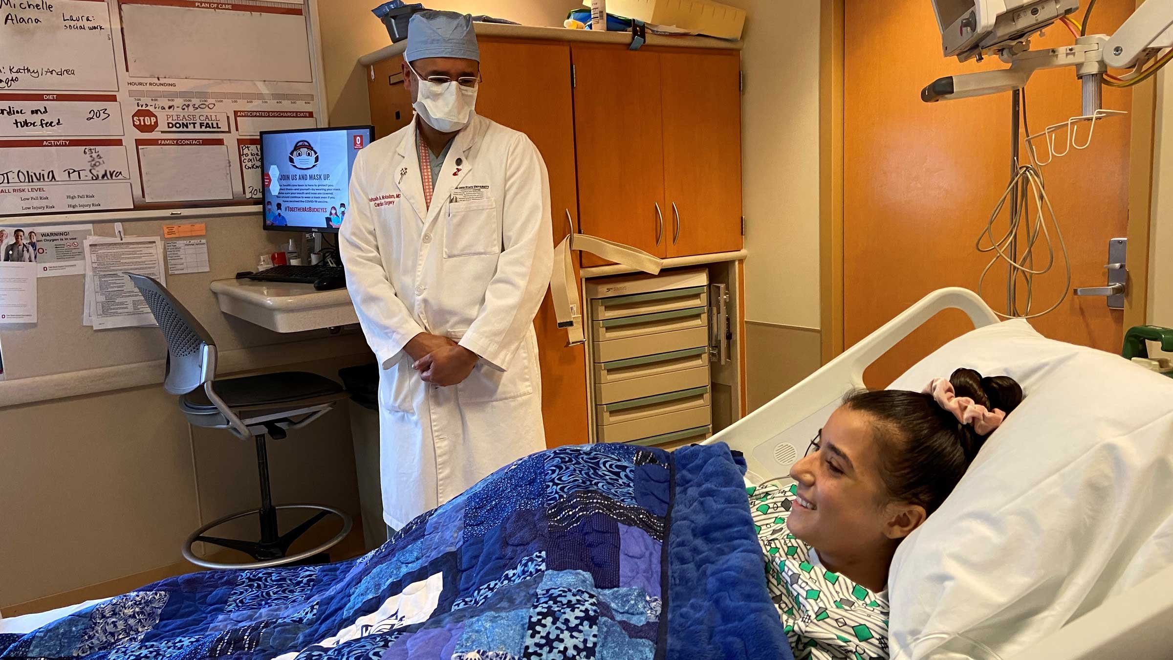 Dr. Mokadam checking in on Gigi who is smiling in her hospital room