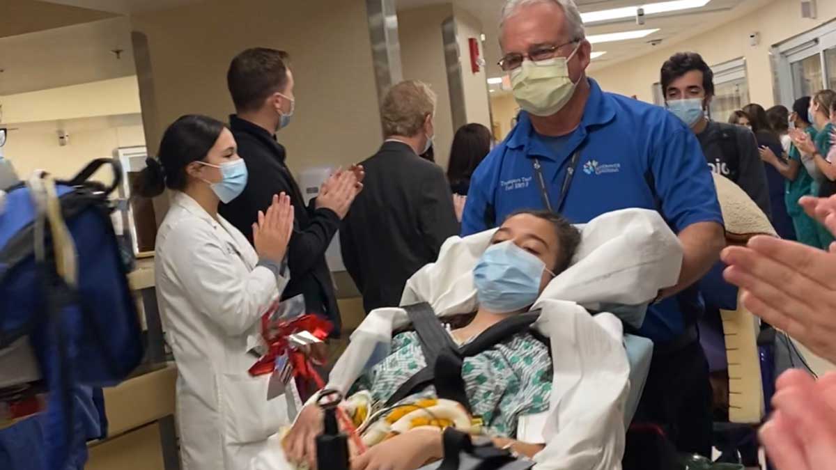 Gigi is wheeled down the hallway at the Ross heart hospital holding a pinweel