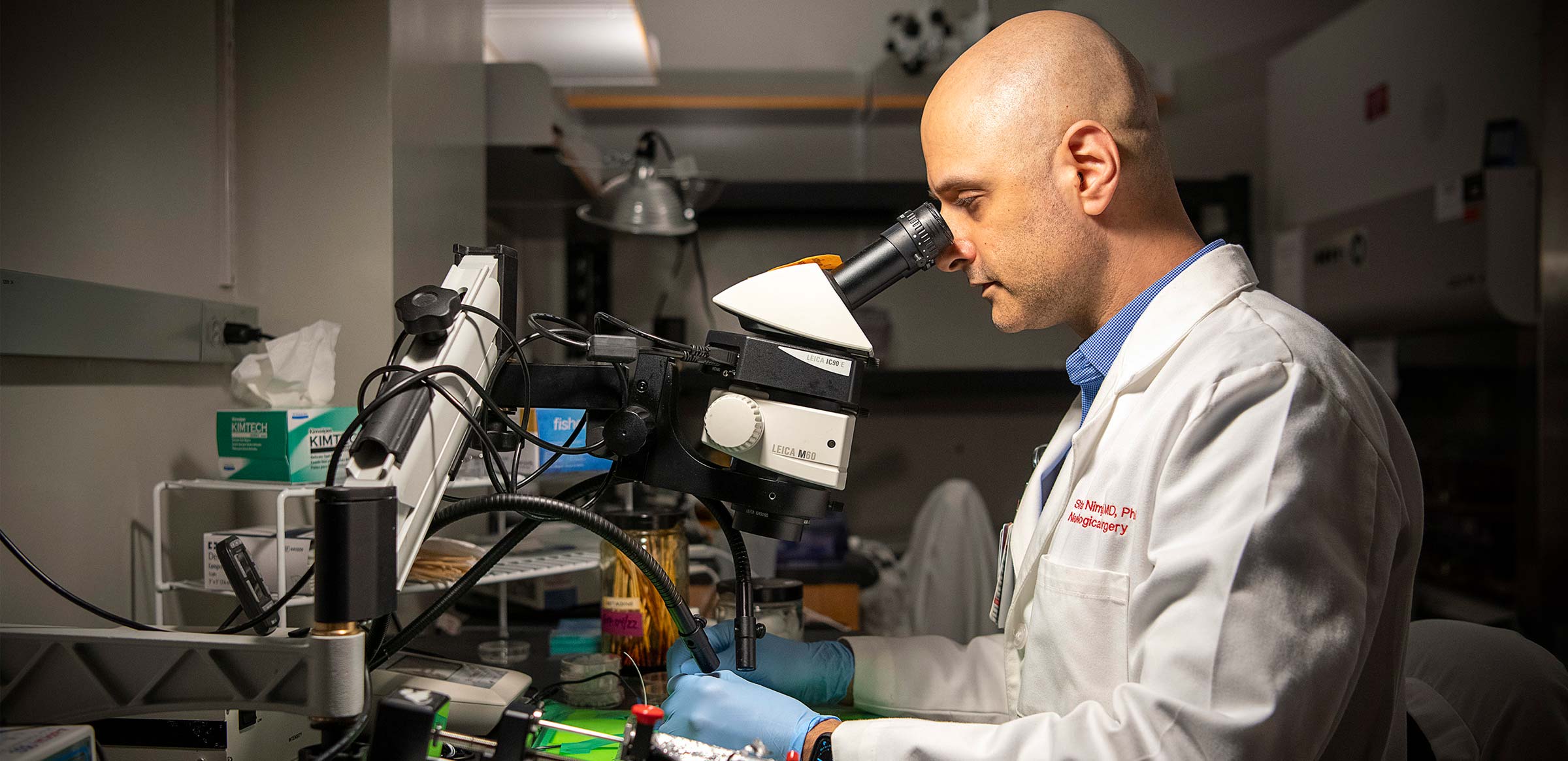 Dr. Shahid Nimjee looking in a microscope