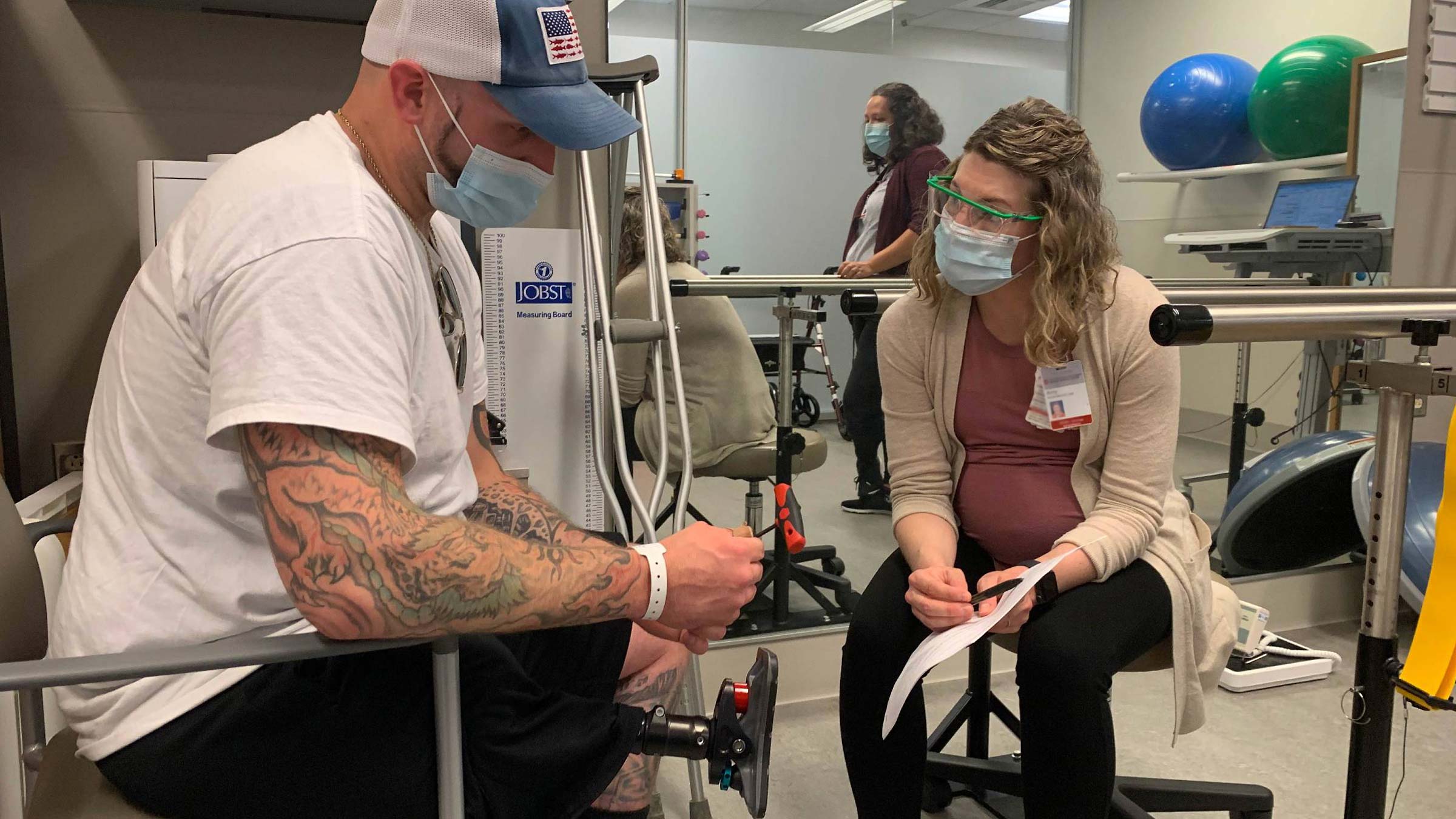 Broc Potts works with physical therapist Amy Compston at OSUCCC – James to learn how to snap on his new prosthetic leg that attaches to a bar surgically implanted into his femur.