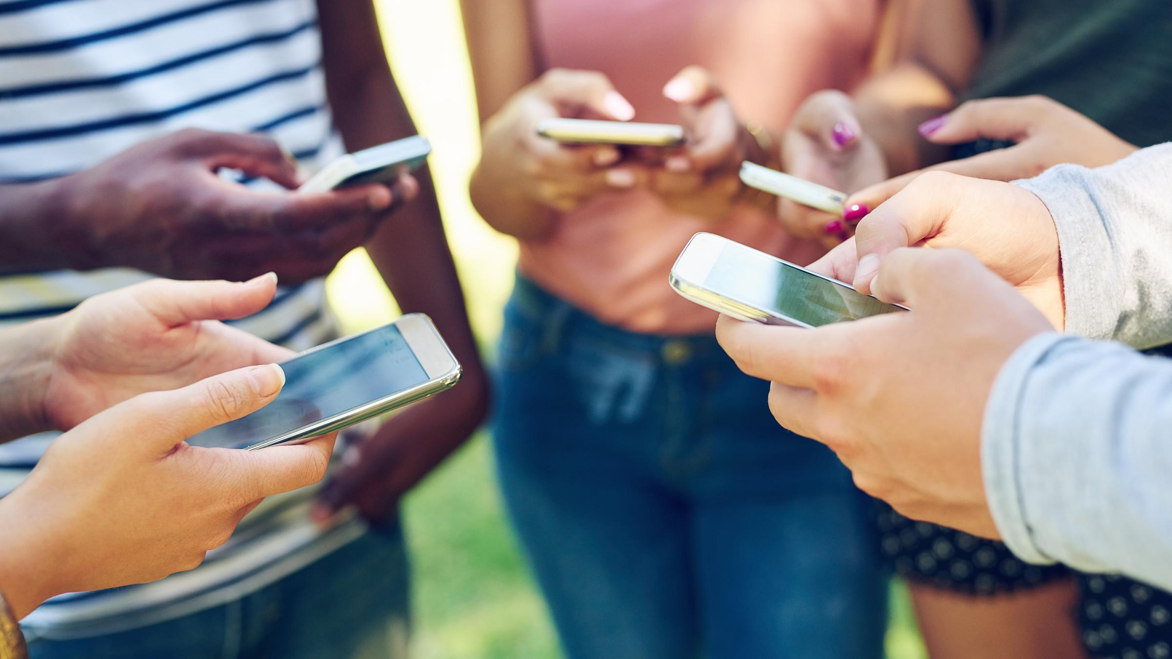 Adults in a circle looking at their phones