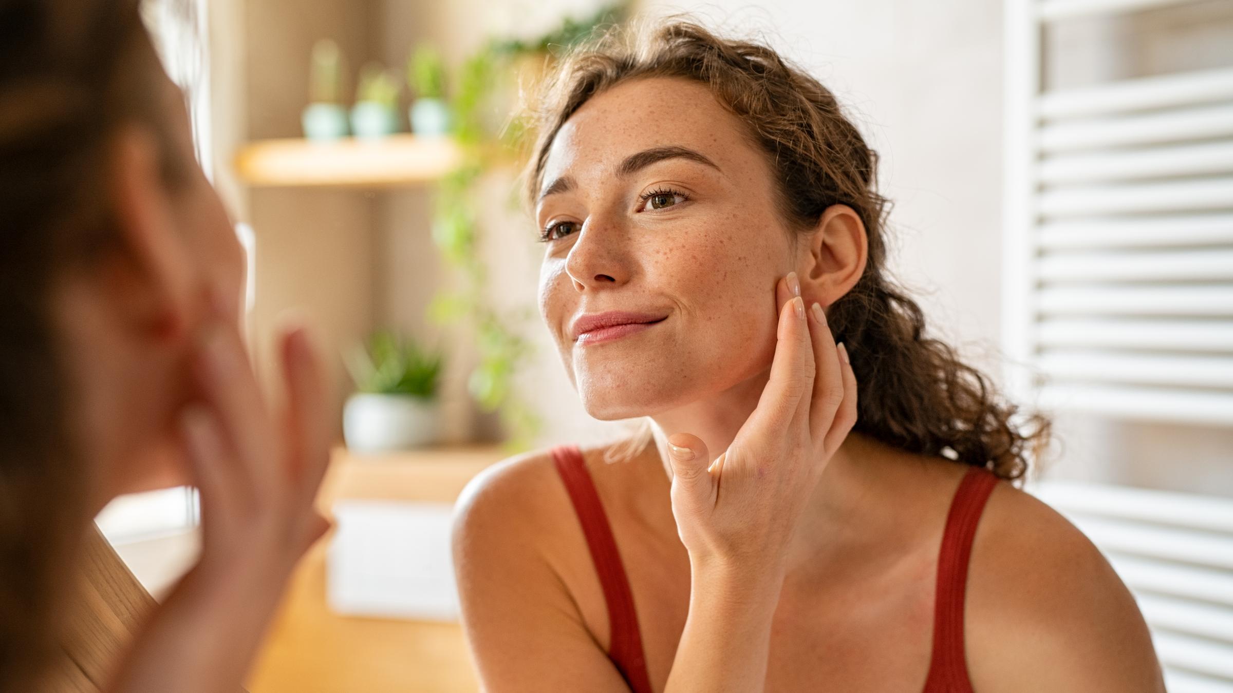 Woman looking at her face in the mirror