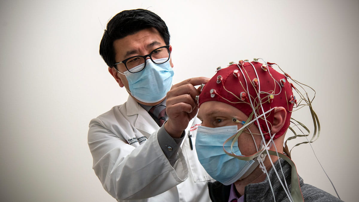 Dr. Phan looking inside the brain with brain mapping cap on patient