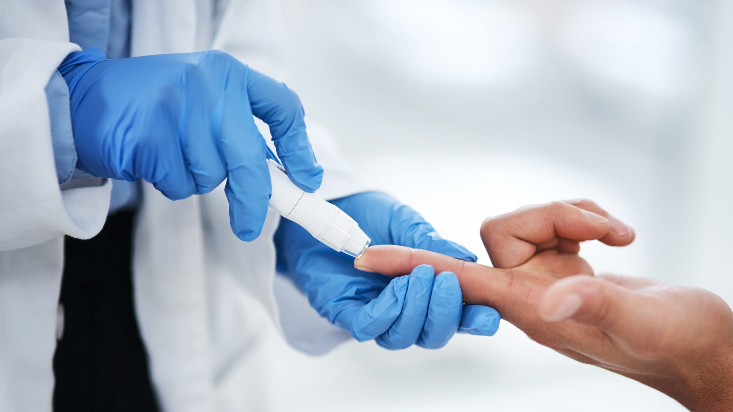 Doctor testing blood sugar on his patient’s finger