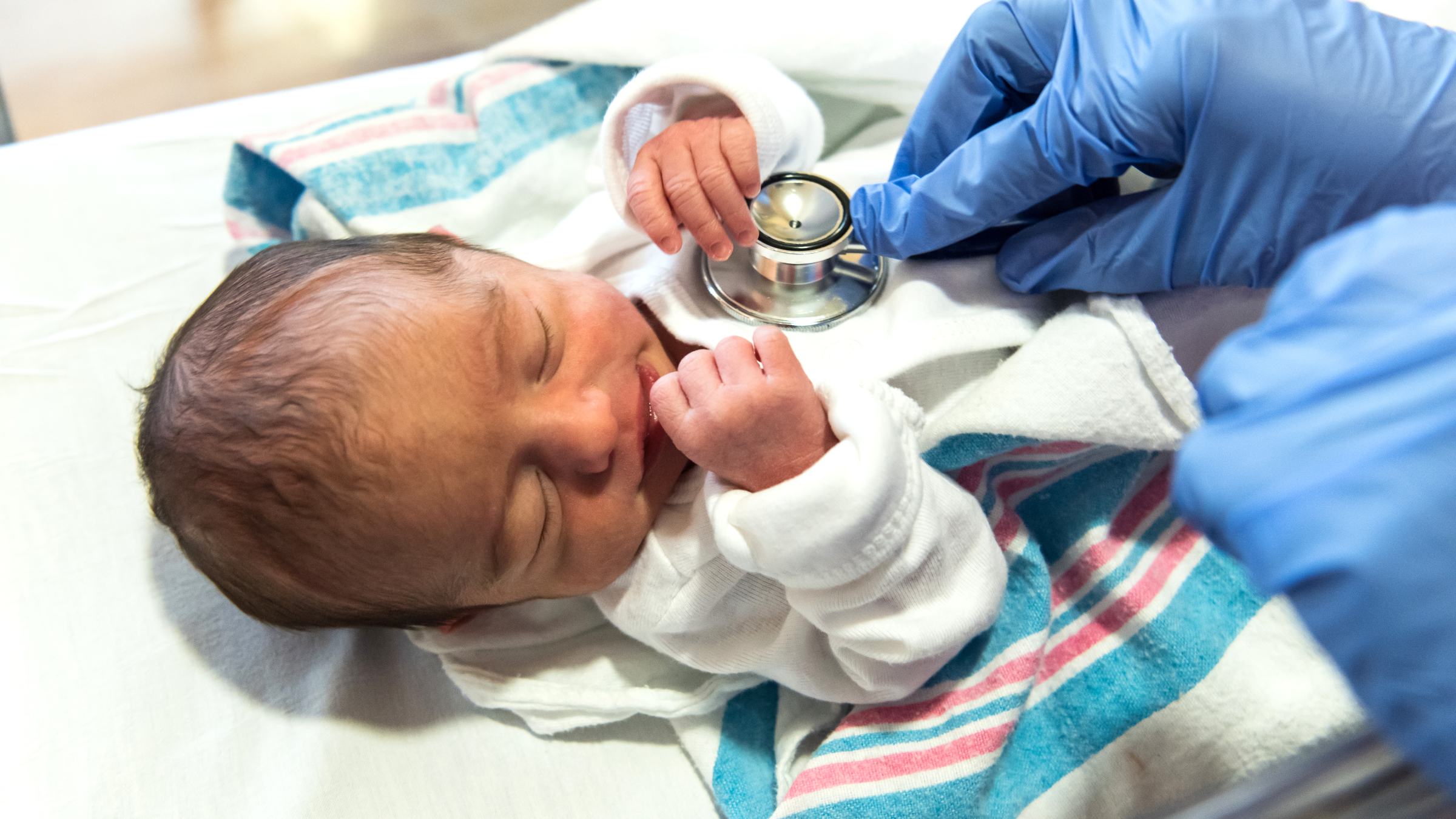 Doctor checking a newborn baby with an stethoscope