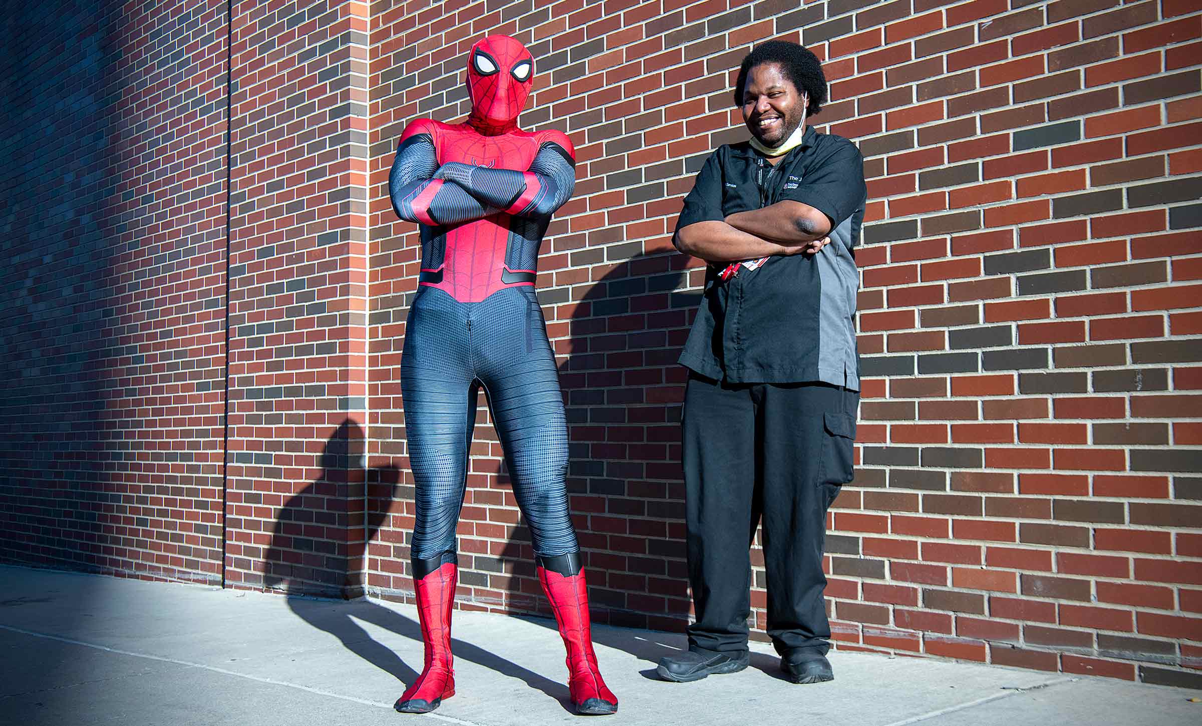Nurse Phil Re in a Spider-Man costume next to his co-worker