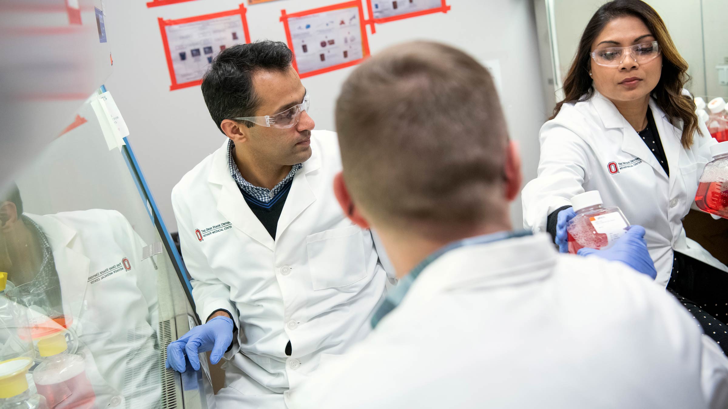 Three scientists at the Ohio State Wexner Medical Center working together in the lab