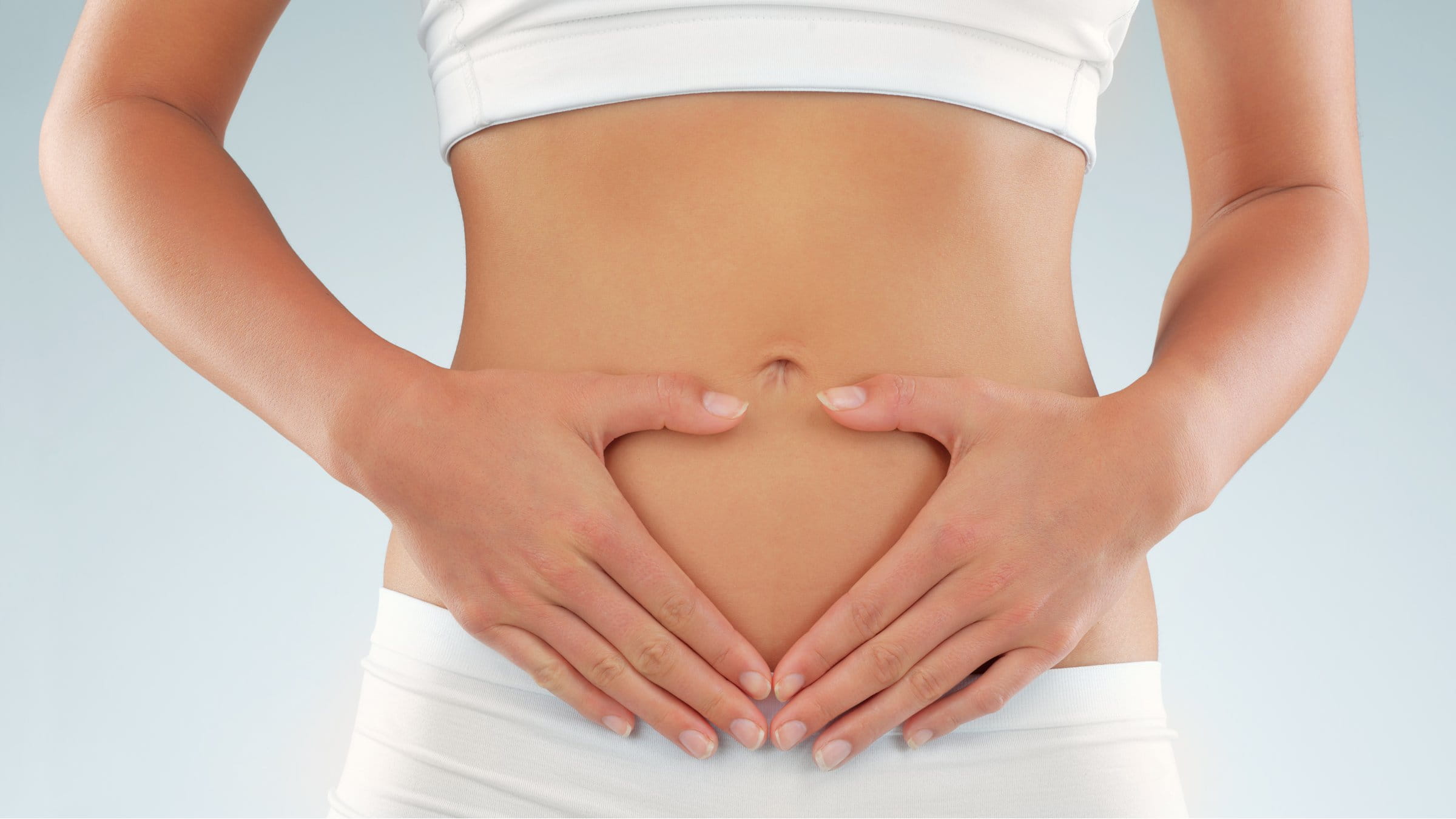 Fit woman holding hands on her stomach