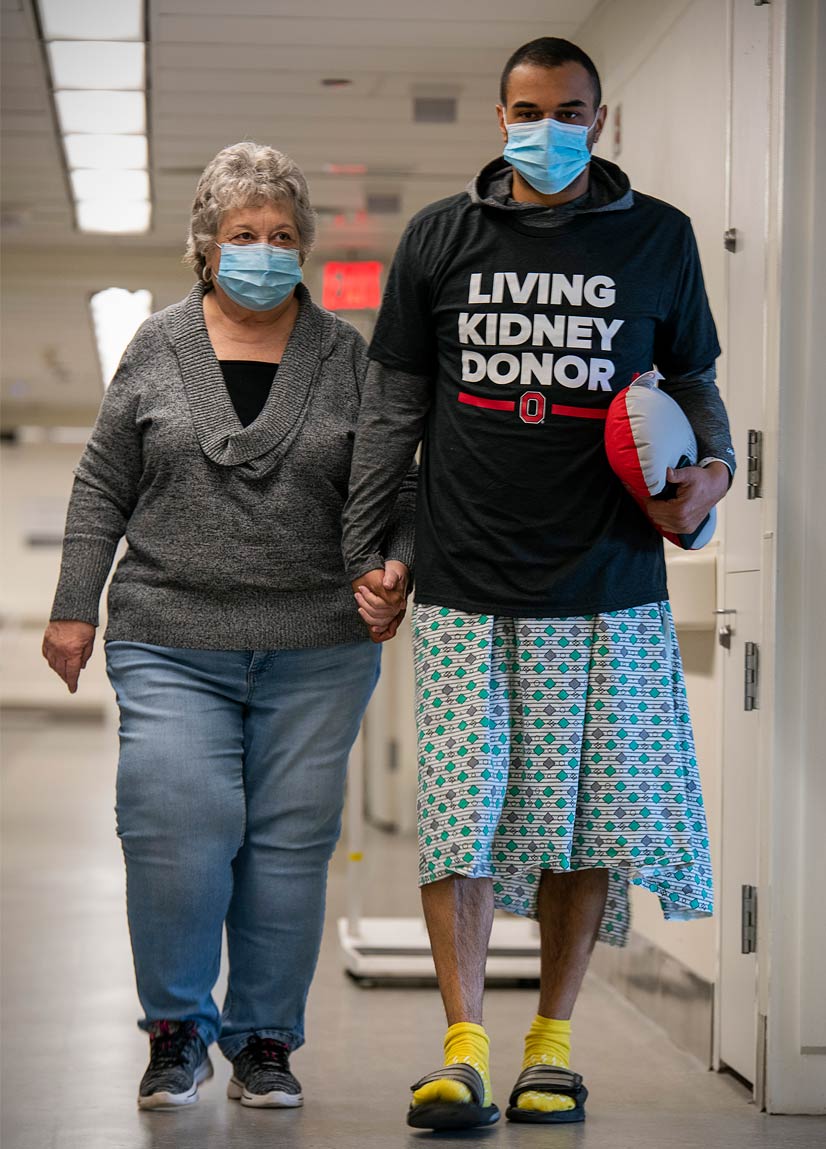 Gail and Josh walking hand in hand down the hospital hallway