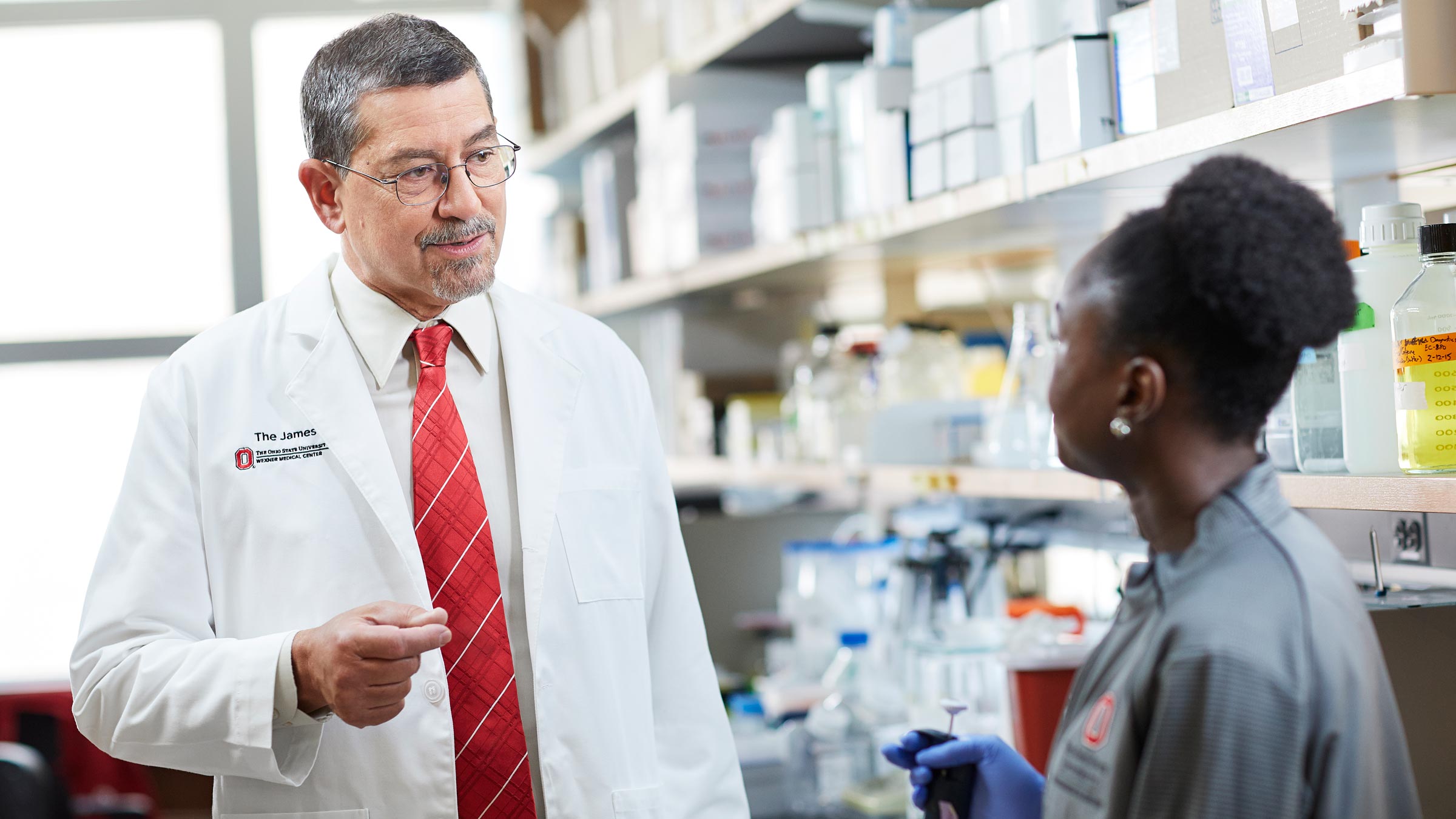 David Carbone, MD, PhD talking with a researcher in an Ohio State lab