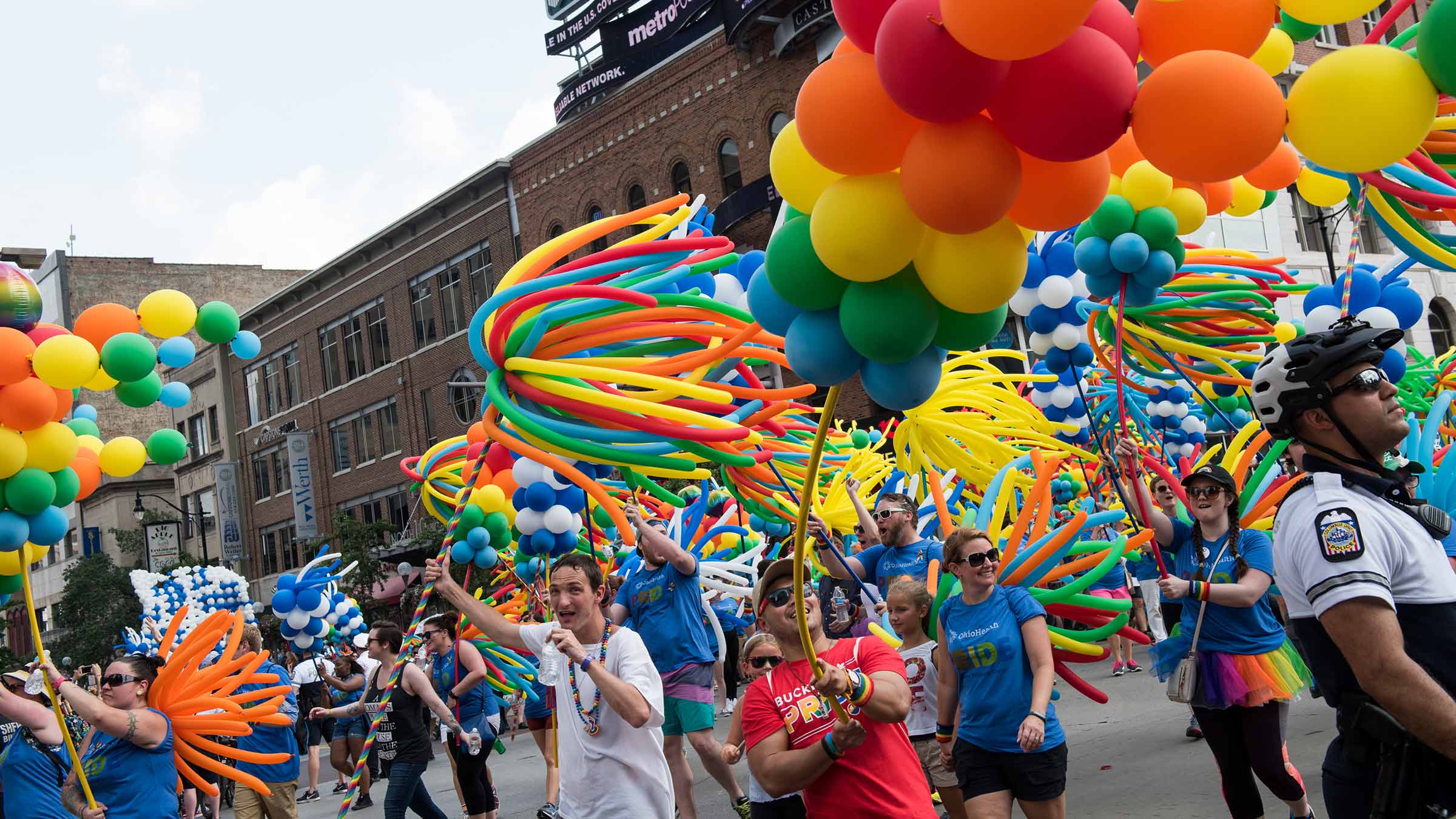 People carrying colorful balloons at the Pride parade