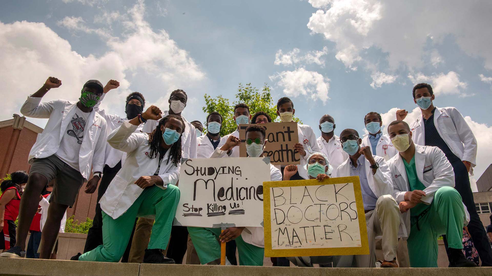 Group of doctors with a sign "Black doctors, don't shoot"