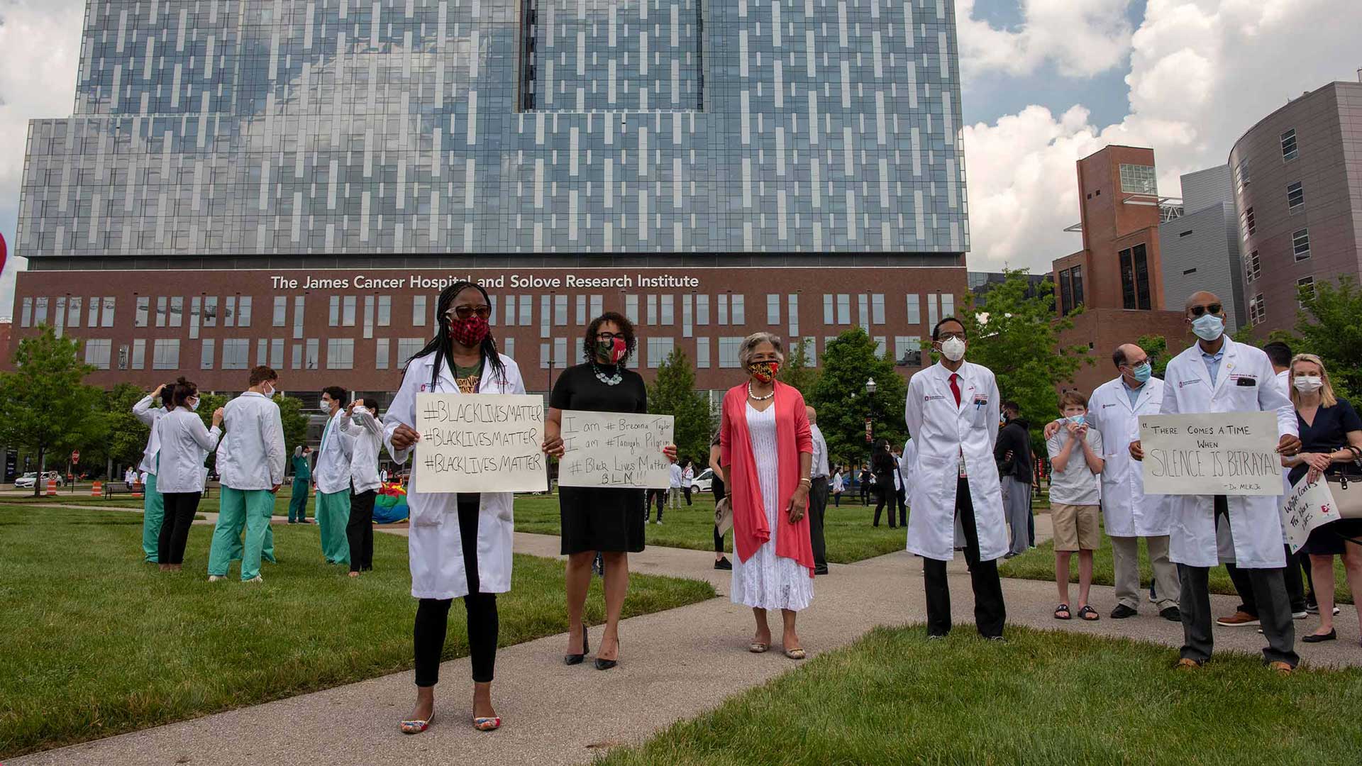 Doctors in front of The James building holding signs