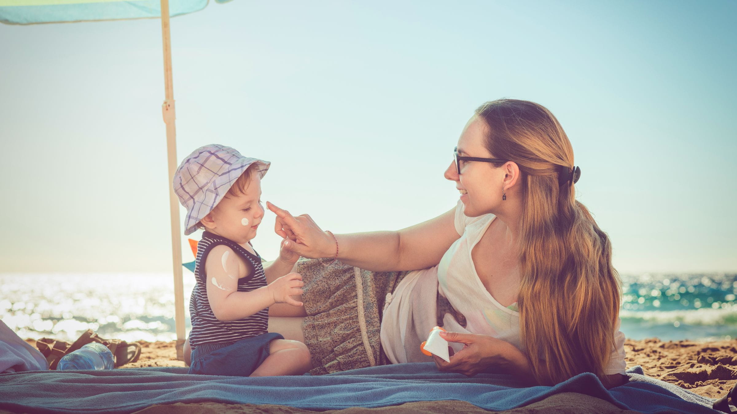 Mother applying sunscreen on her kid