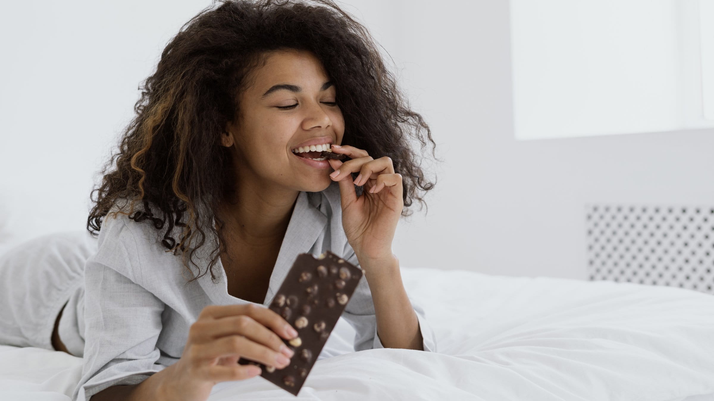 Woman biting on a piece of chocolate