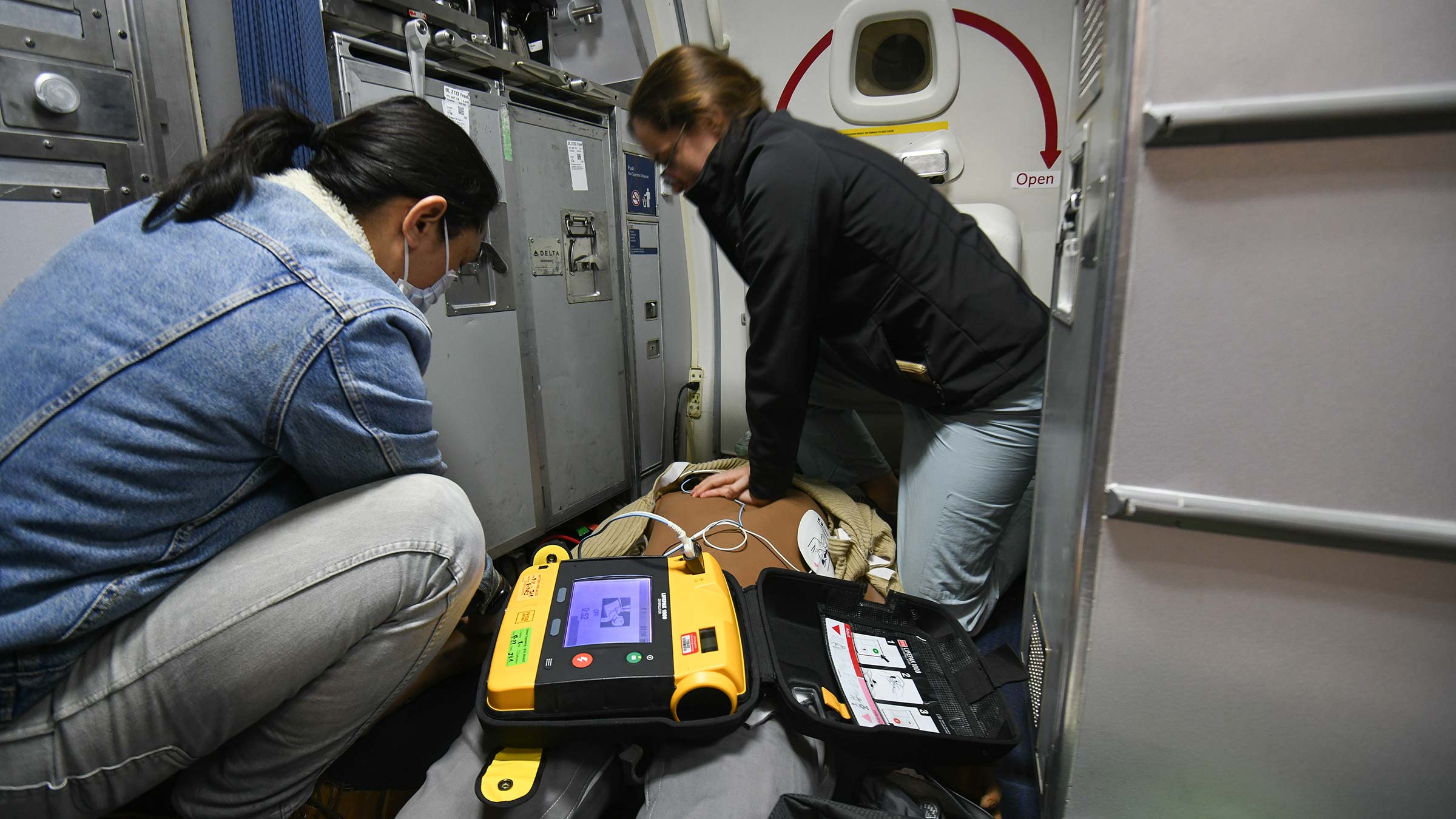 Students practicing CPR in an airplane