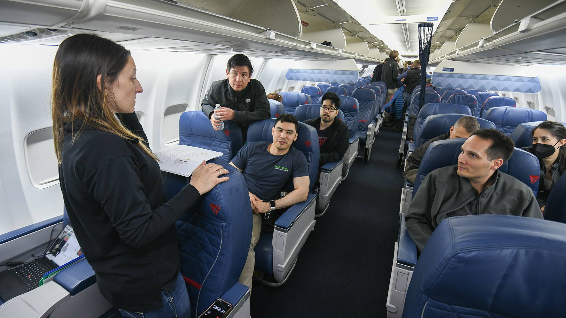 Students listening to their teacher on an airplane