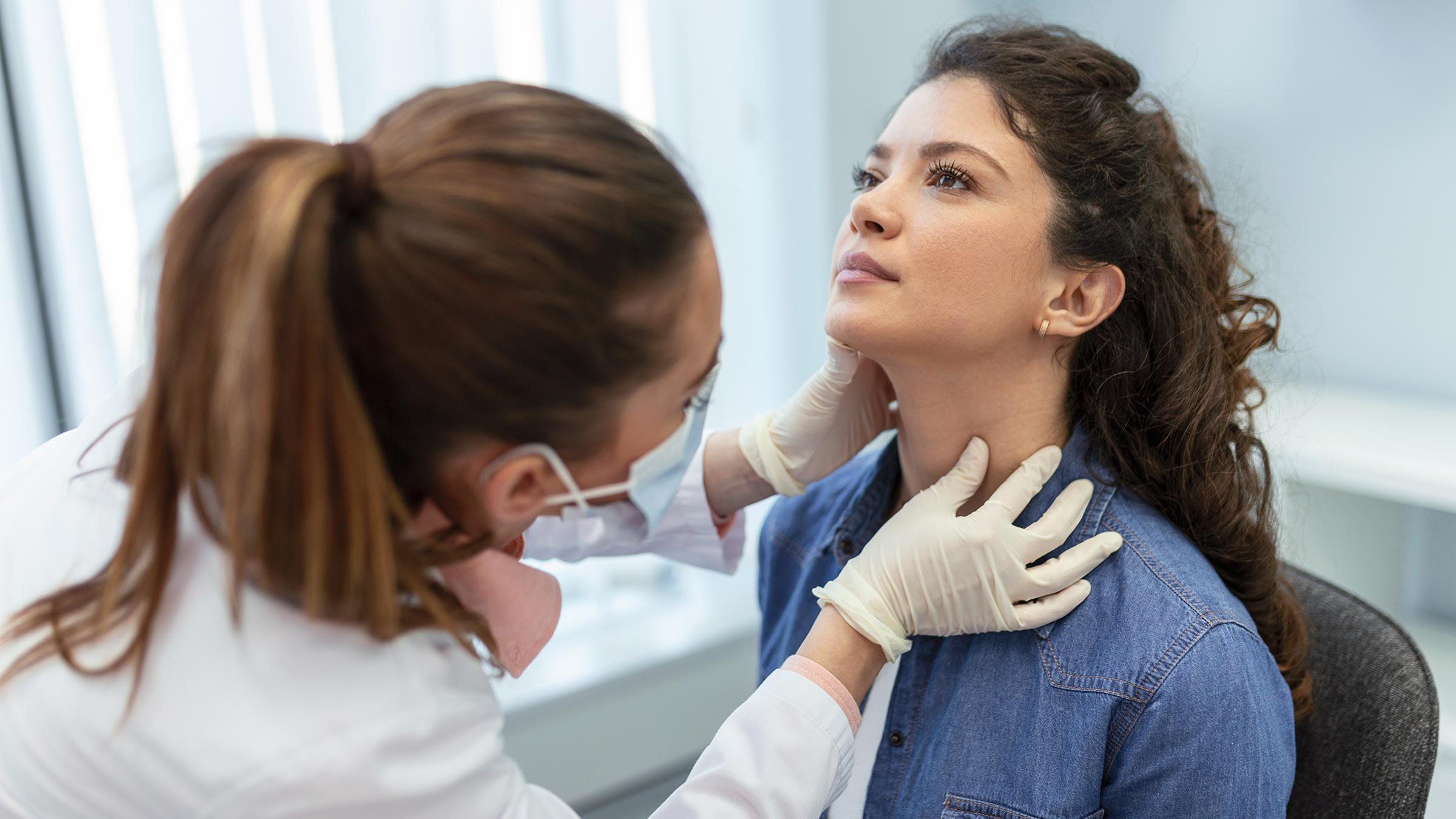 Doctor checking a patient's thyroid gland