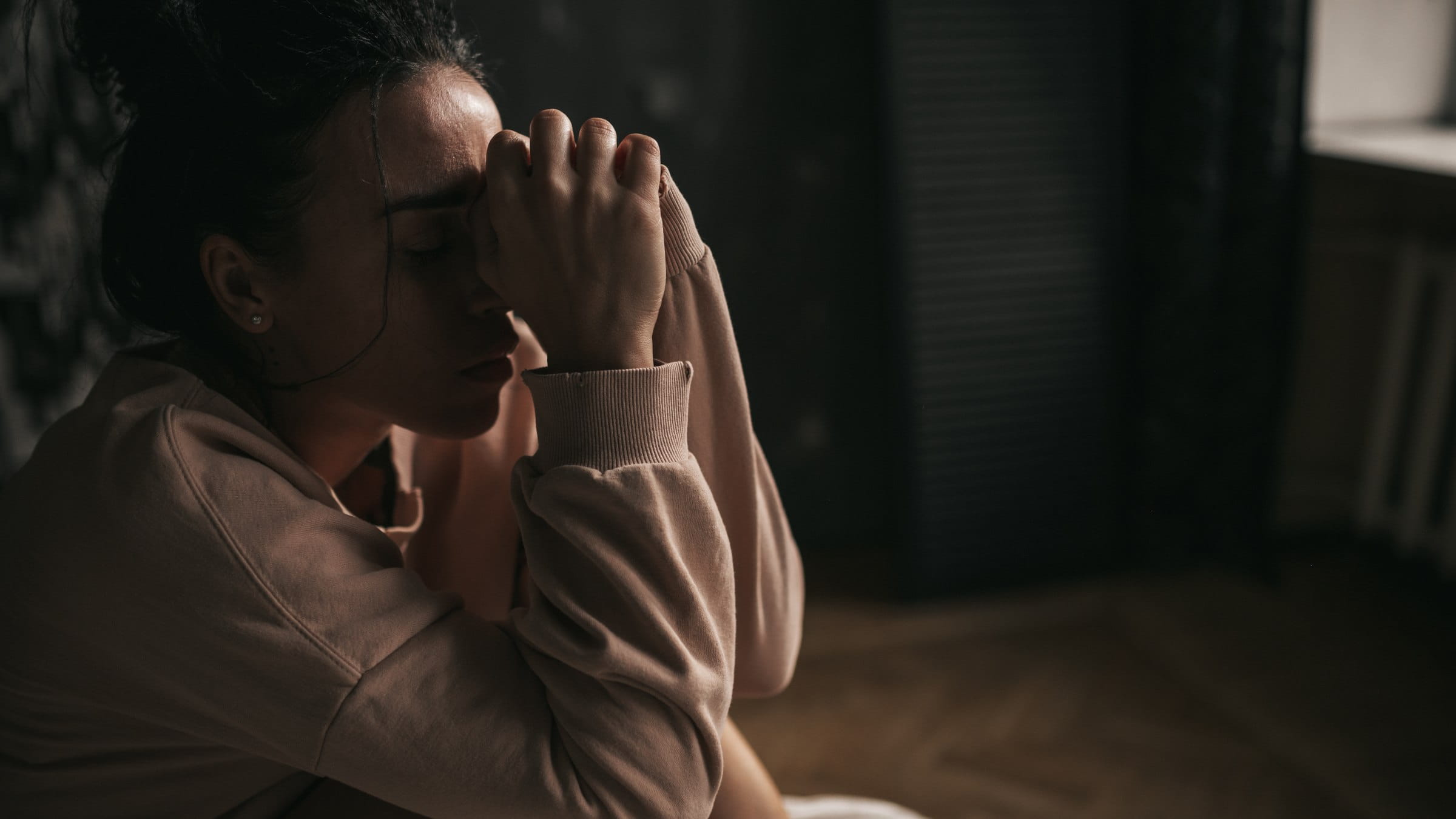 Woman exhausted sitting in the darkness