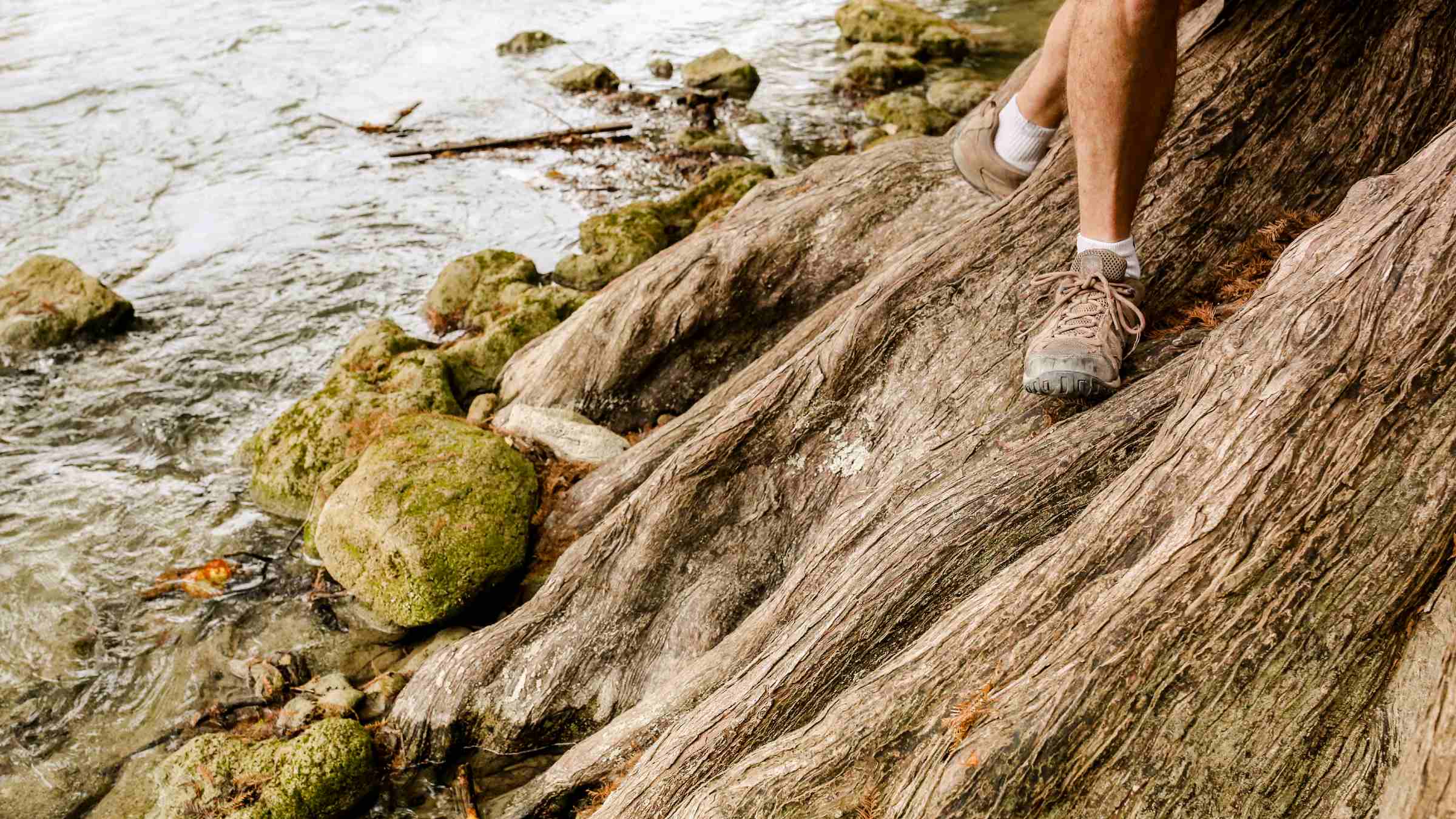 Feet of a man hiking through a rough terrain