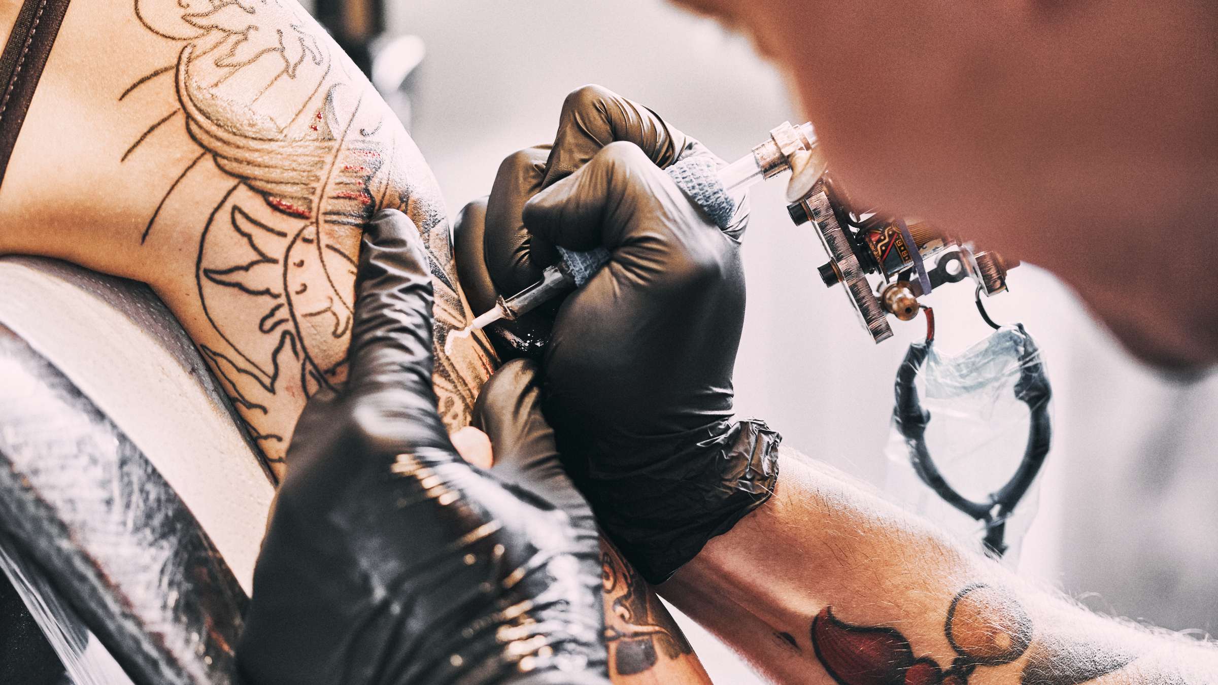 Tattoo artist making a tattoo on a shoulder