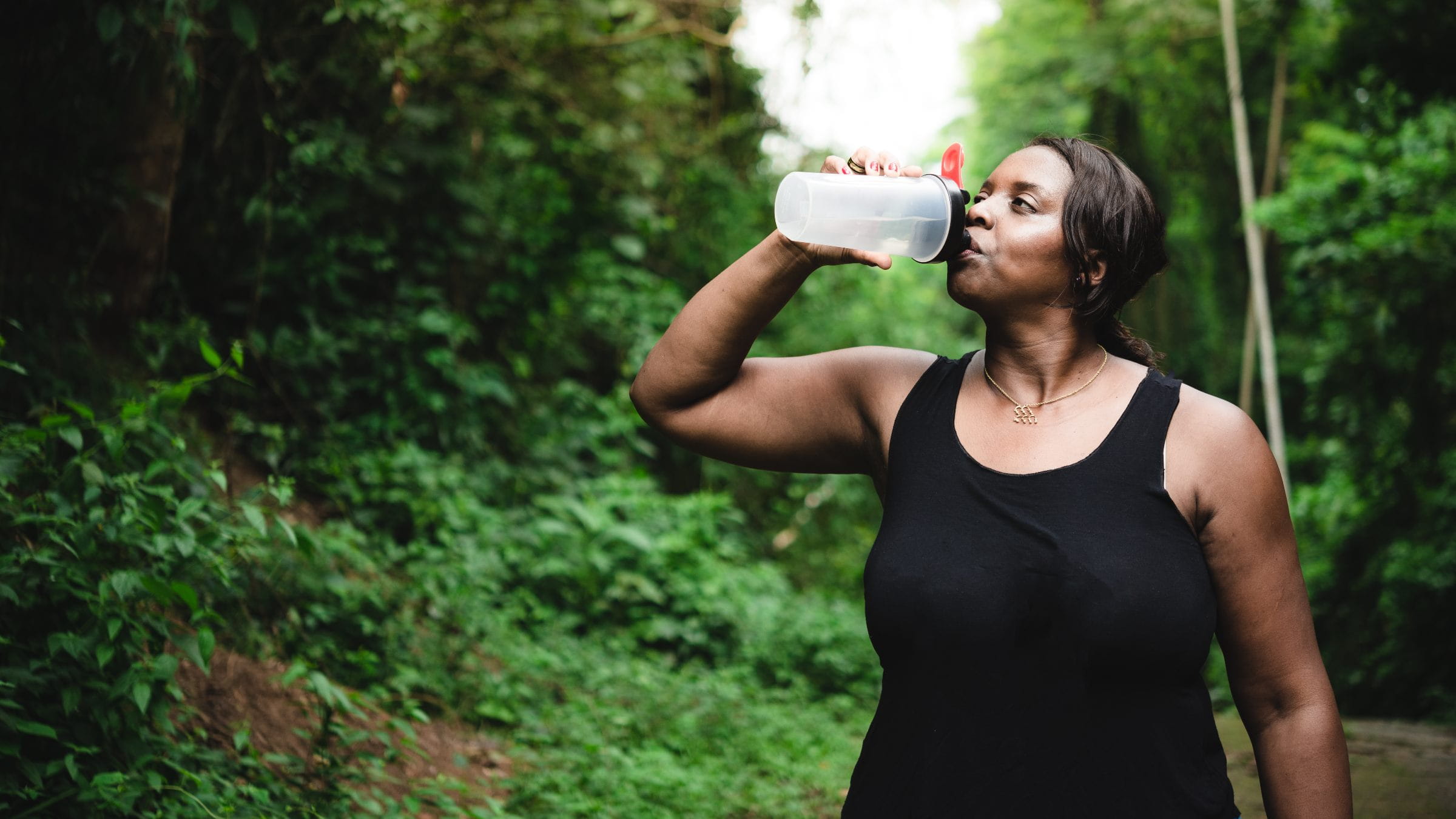 Woman on a trail drinking water