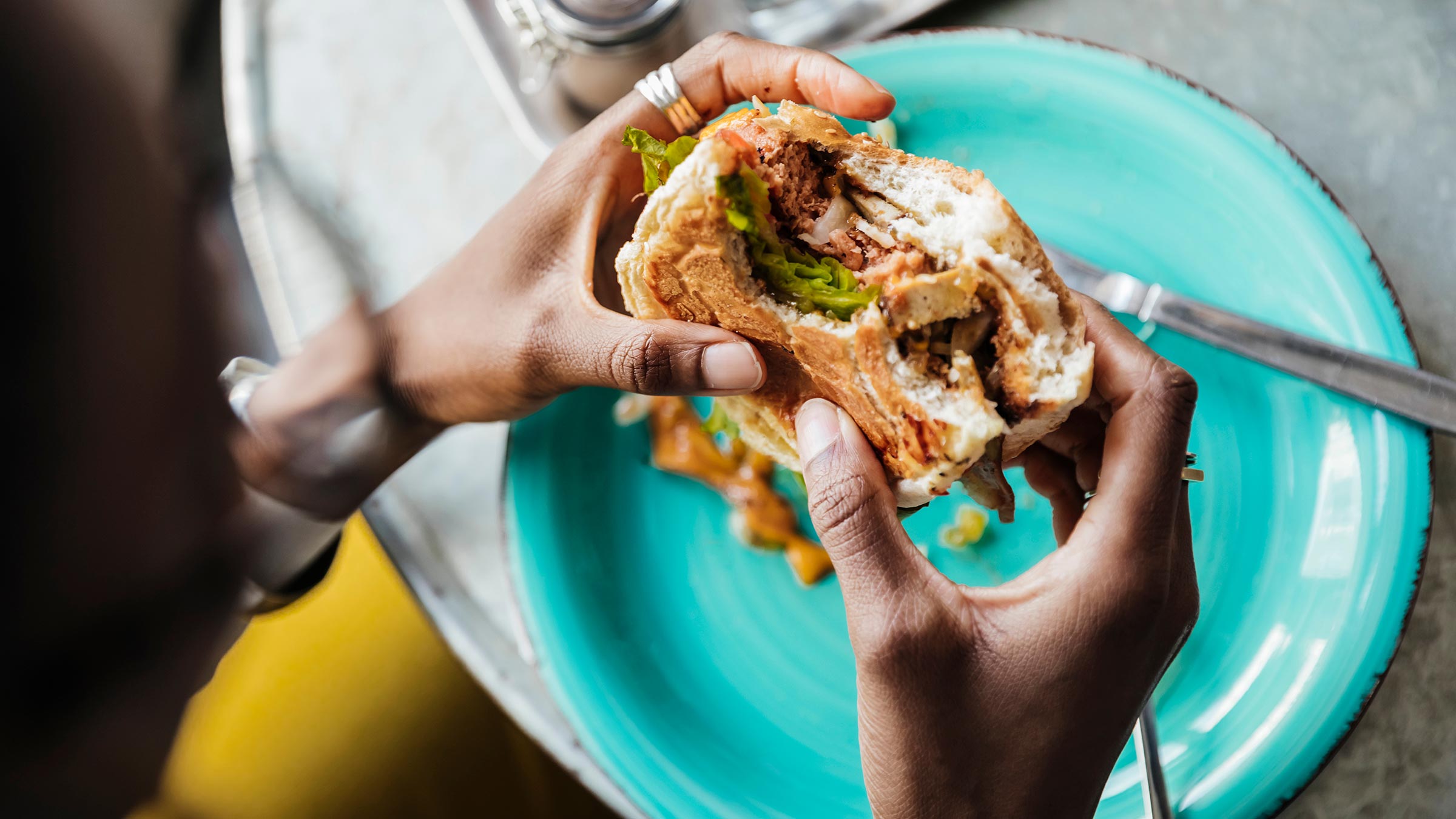 Woman eats plant-based meat sandwich