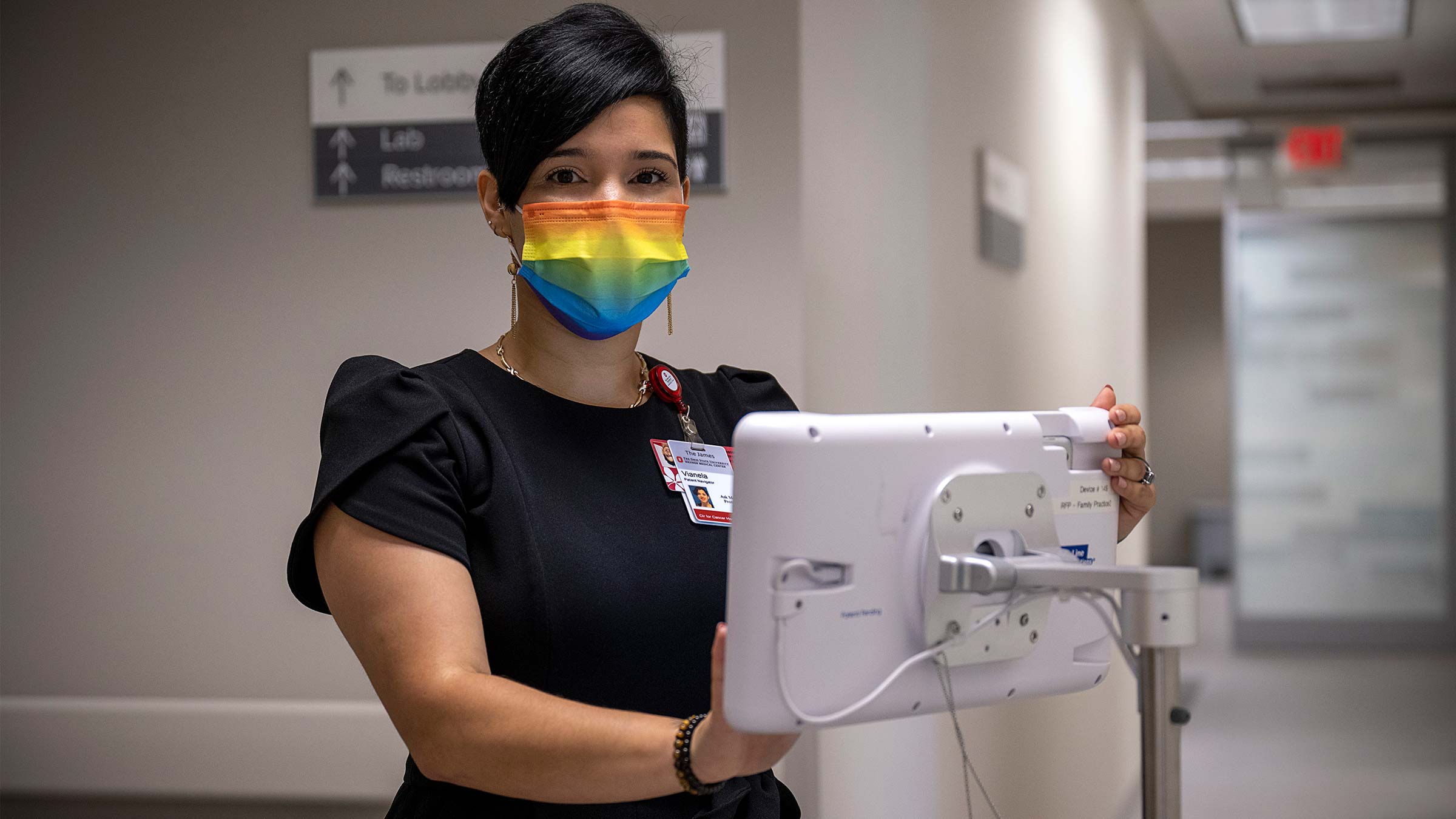 Patient navigator, Vianela Ramery, standing with computer