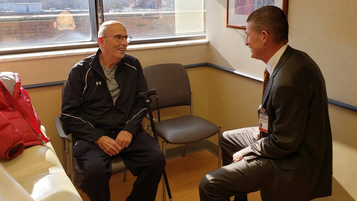 Dr. Washburn talking to Dr. Steinburg in a clinic room