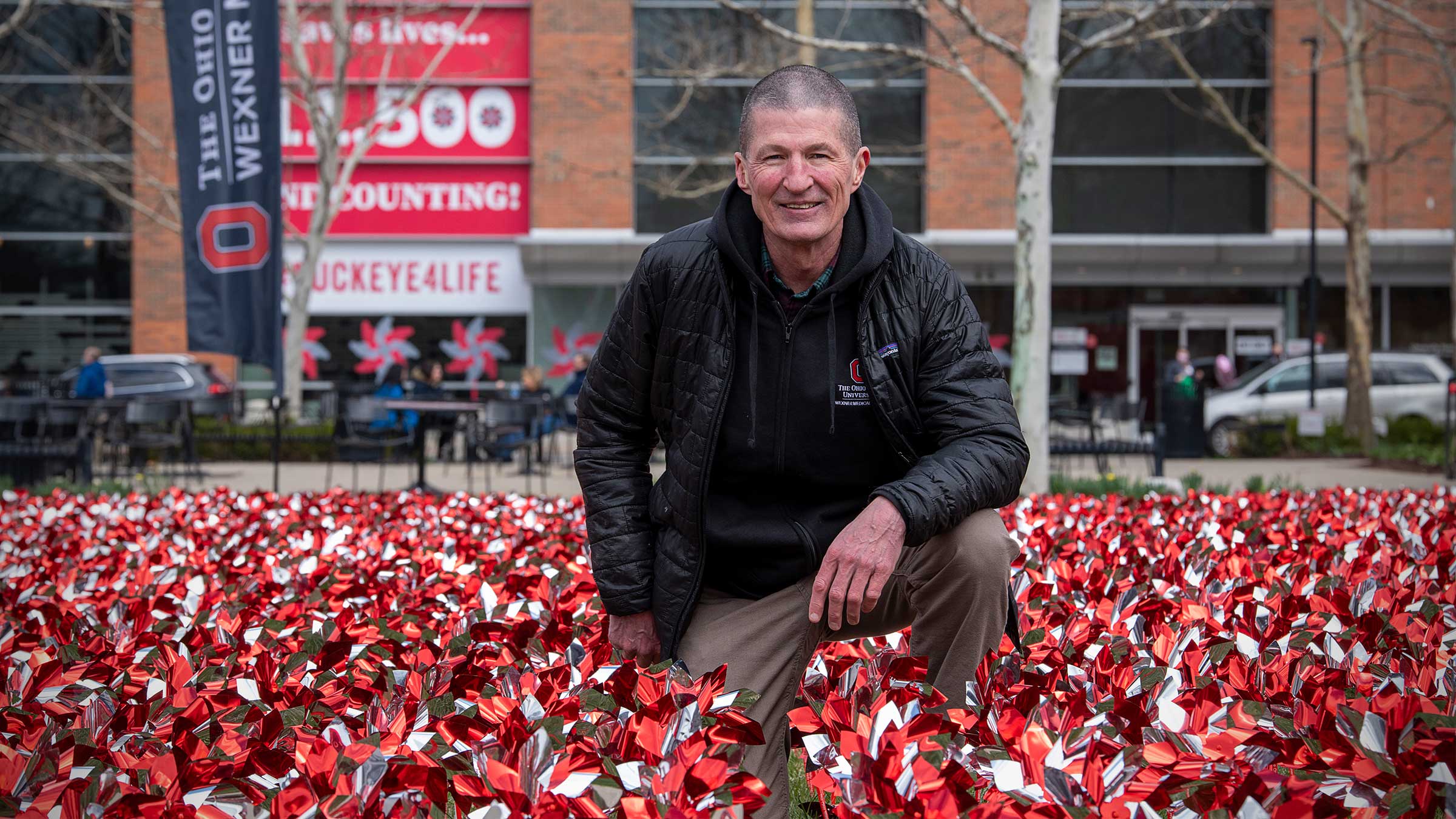 Dr. Washburn standing in from of the medical center with pinwheels