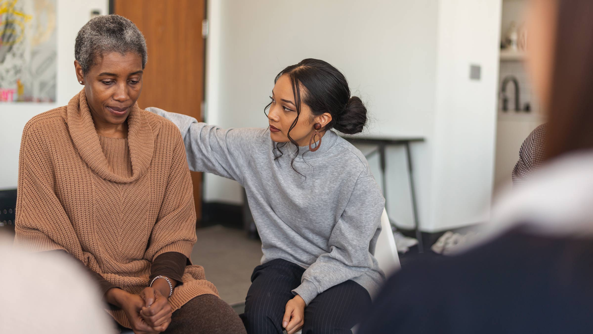 Grief support group member comforting a woman