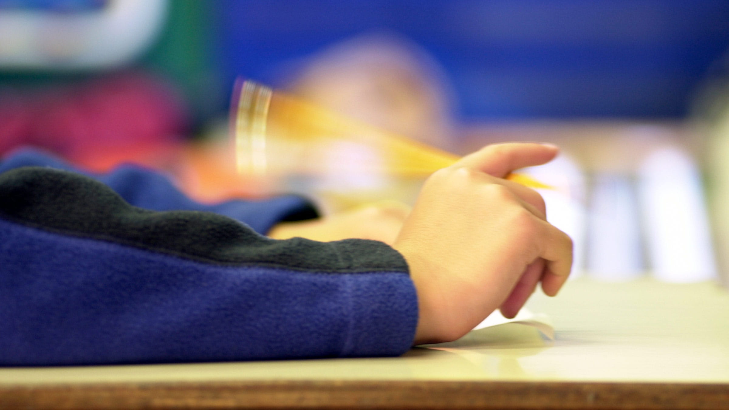 Hands flicking pencil on desk