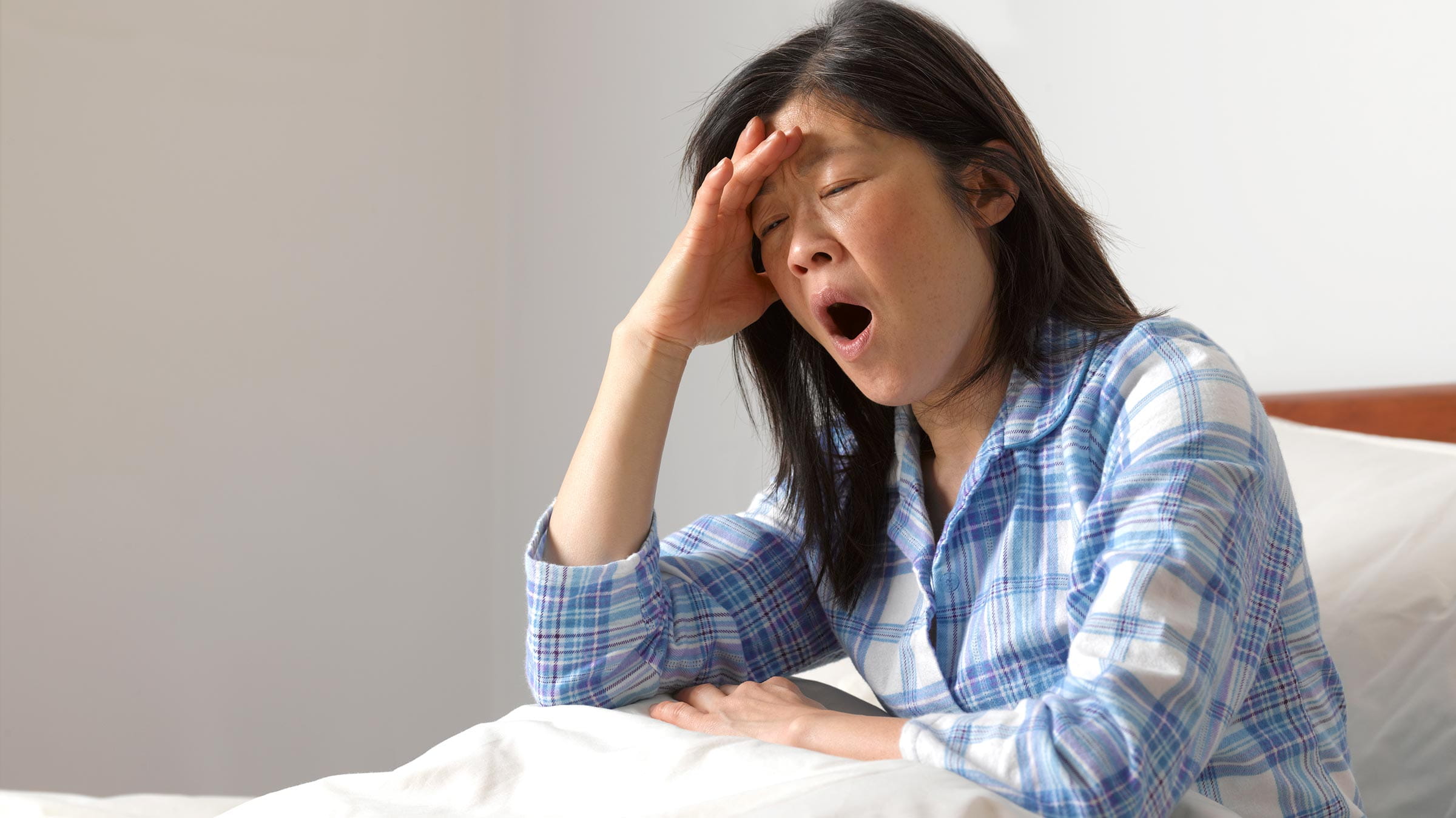 Woman yawning in bed