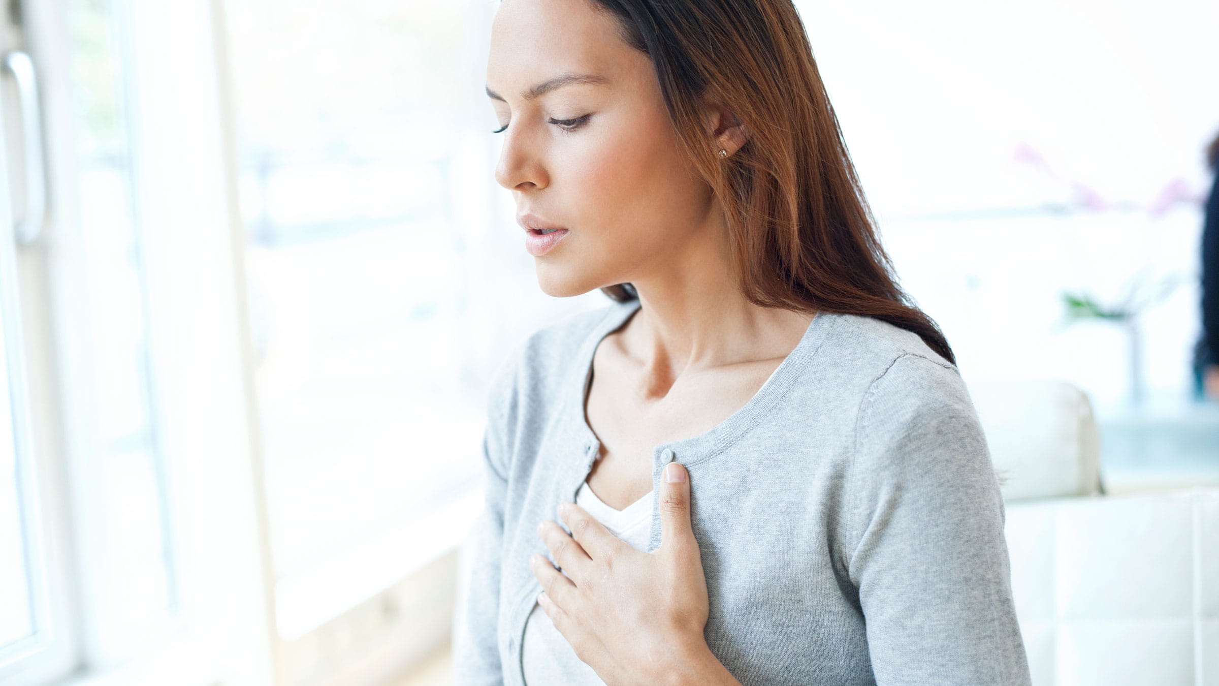 Woman holding a hand on her chest