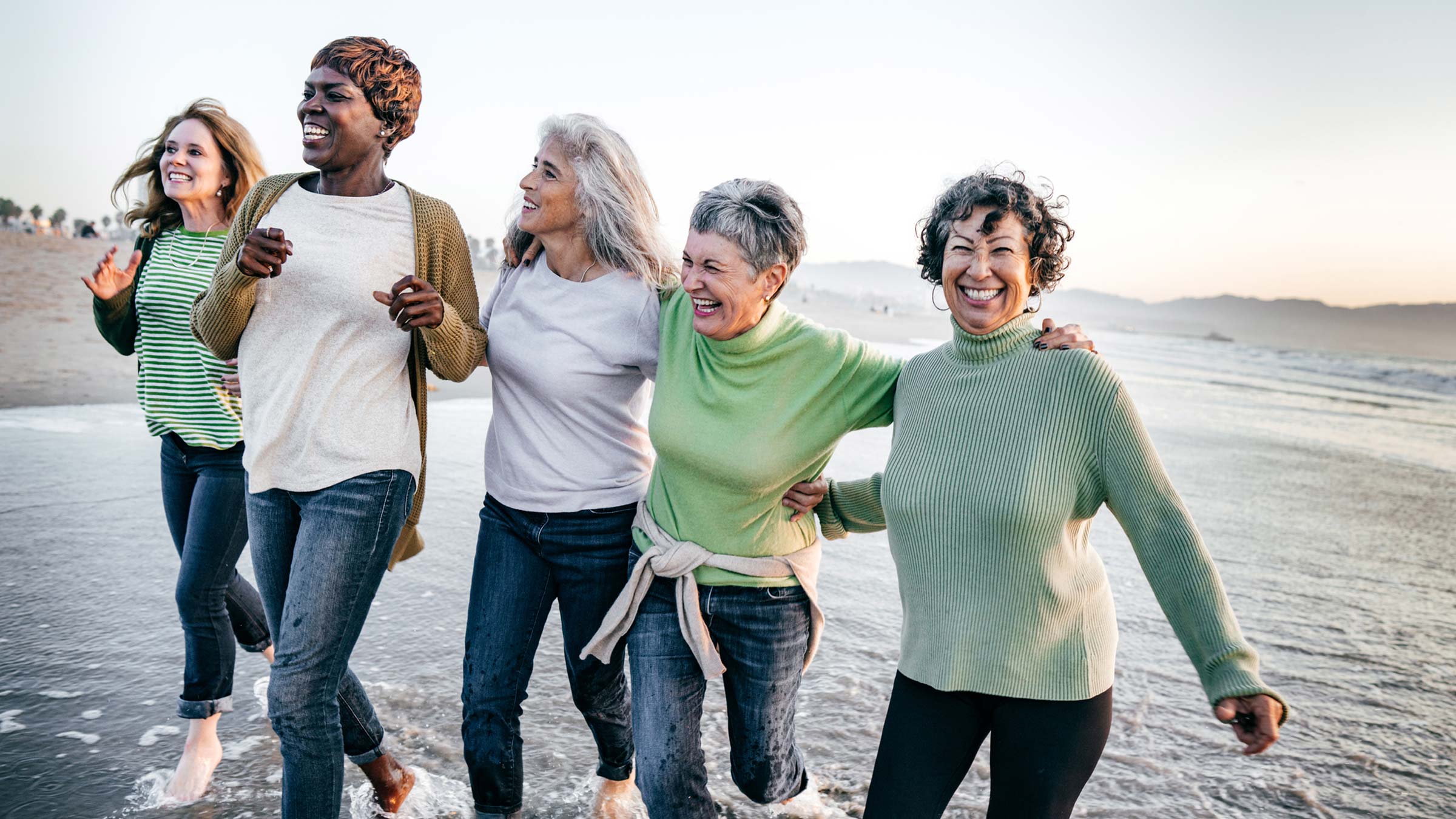 A group of older women running on the beach