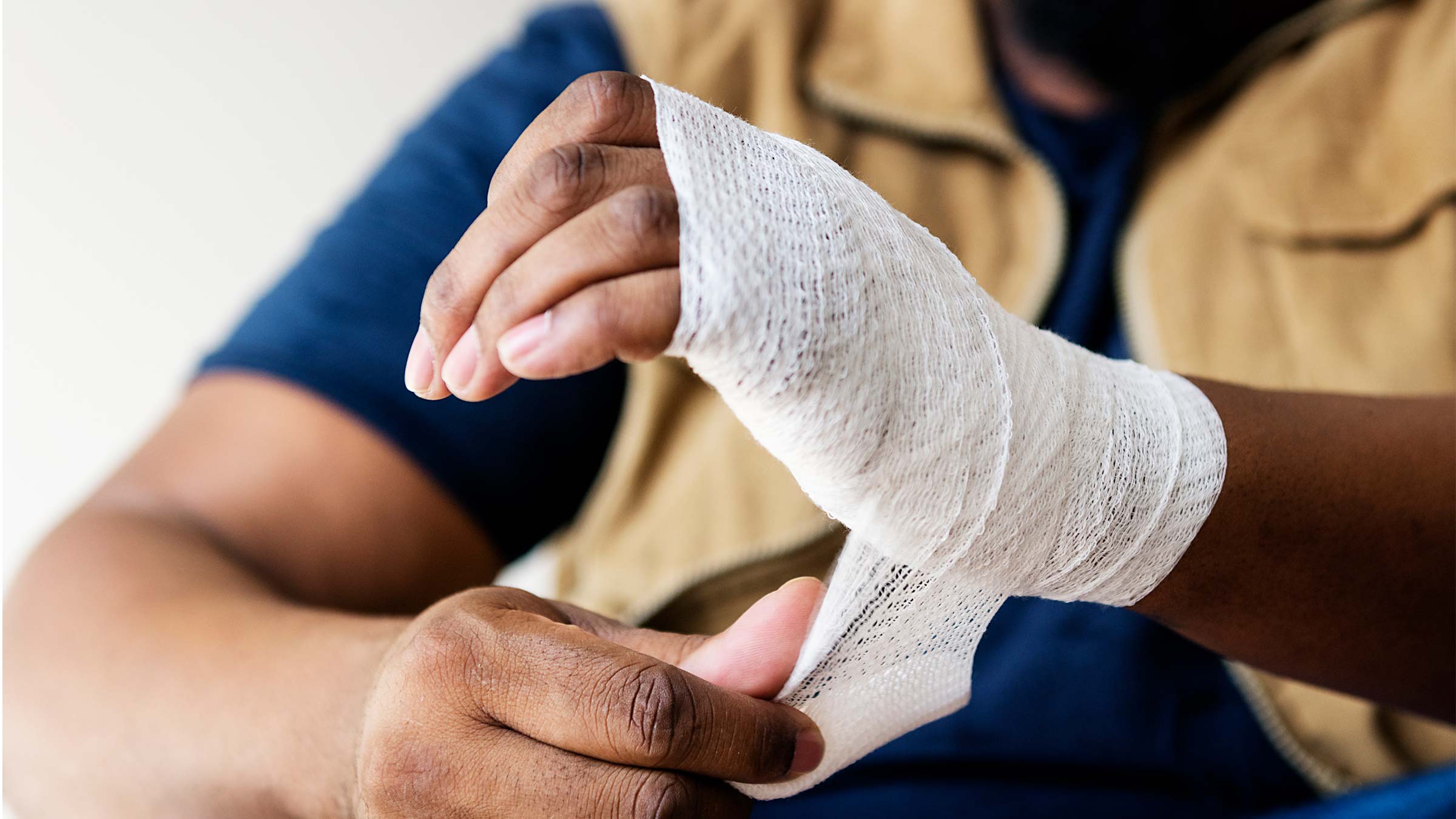 A man wraps a wound on his hand