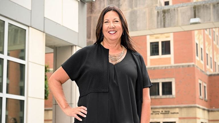 Jackie Hoying, PhD, RN, standing in front of the Biomedical Research Tower at Ohio State