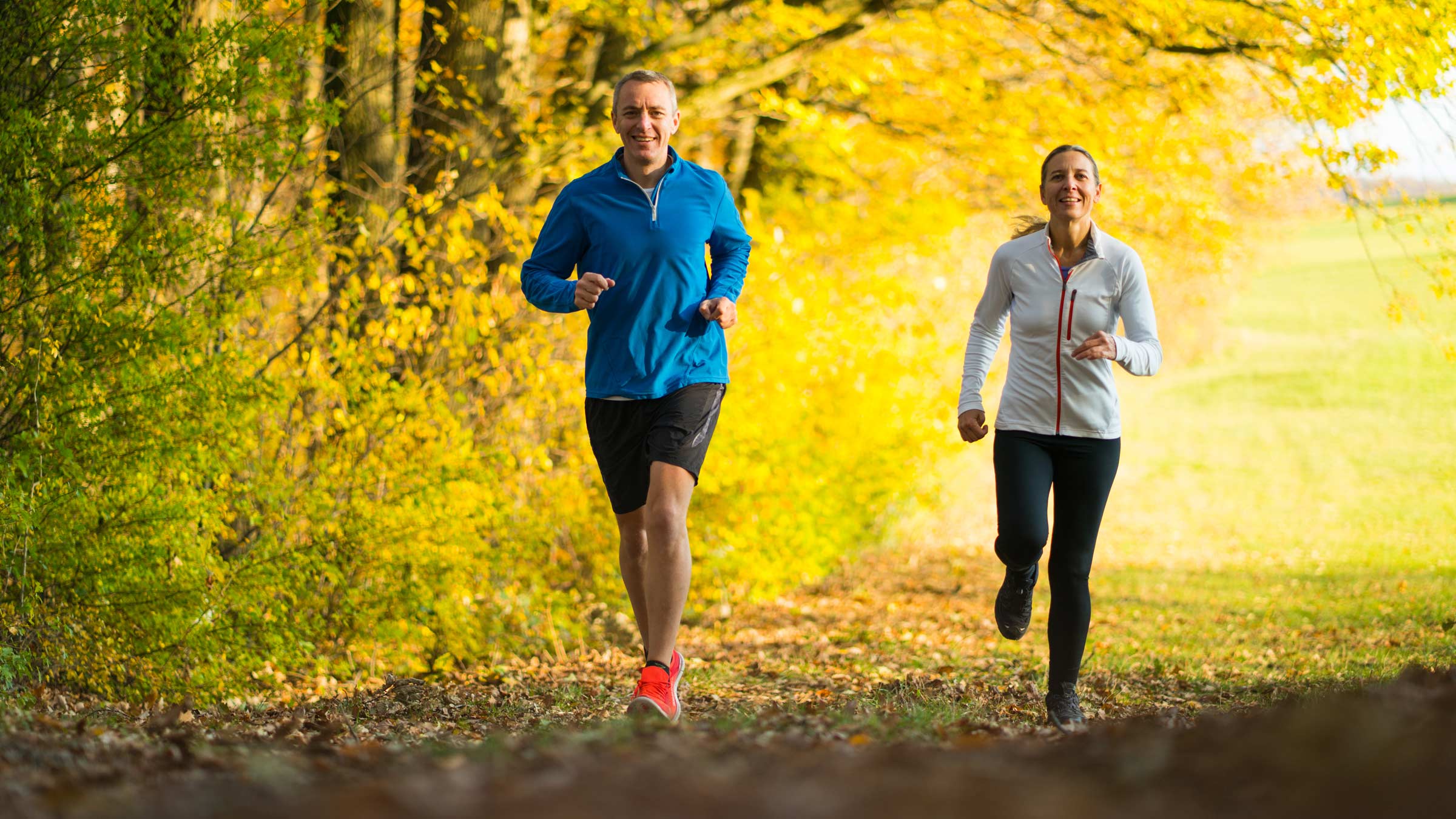 A man and woman running outside