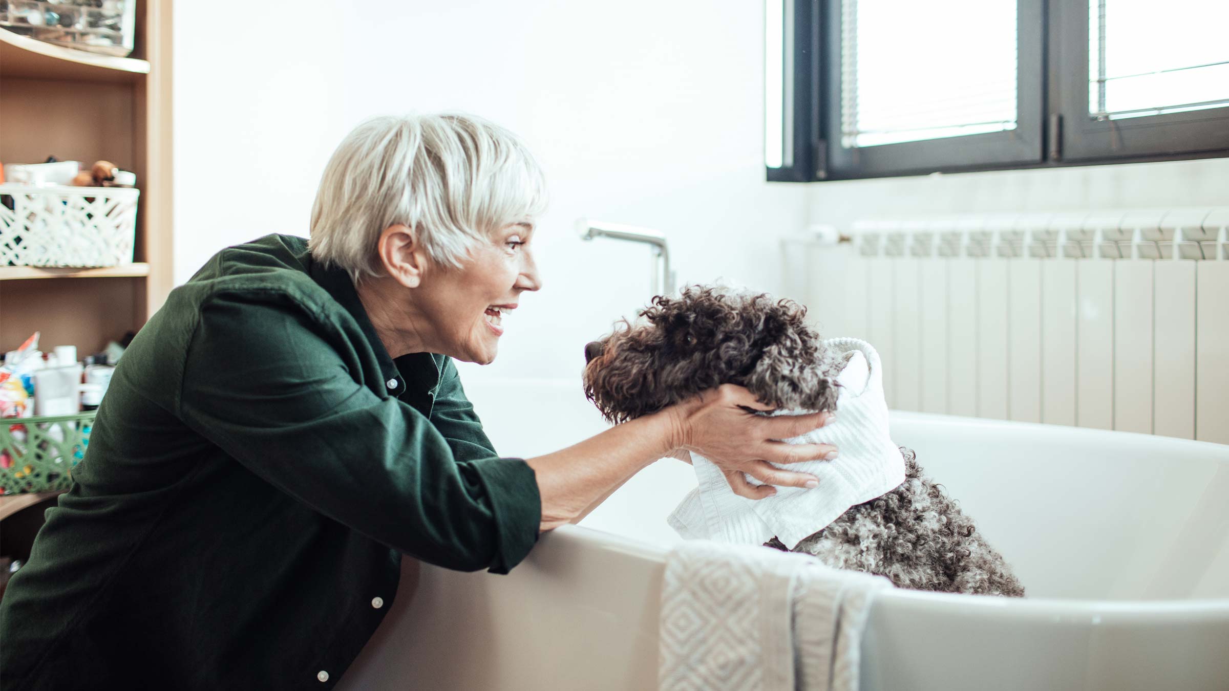 Senior woman giving her dog a bath